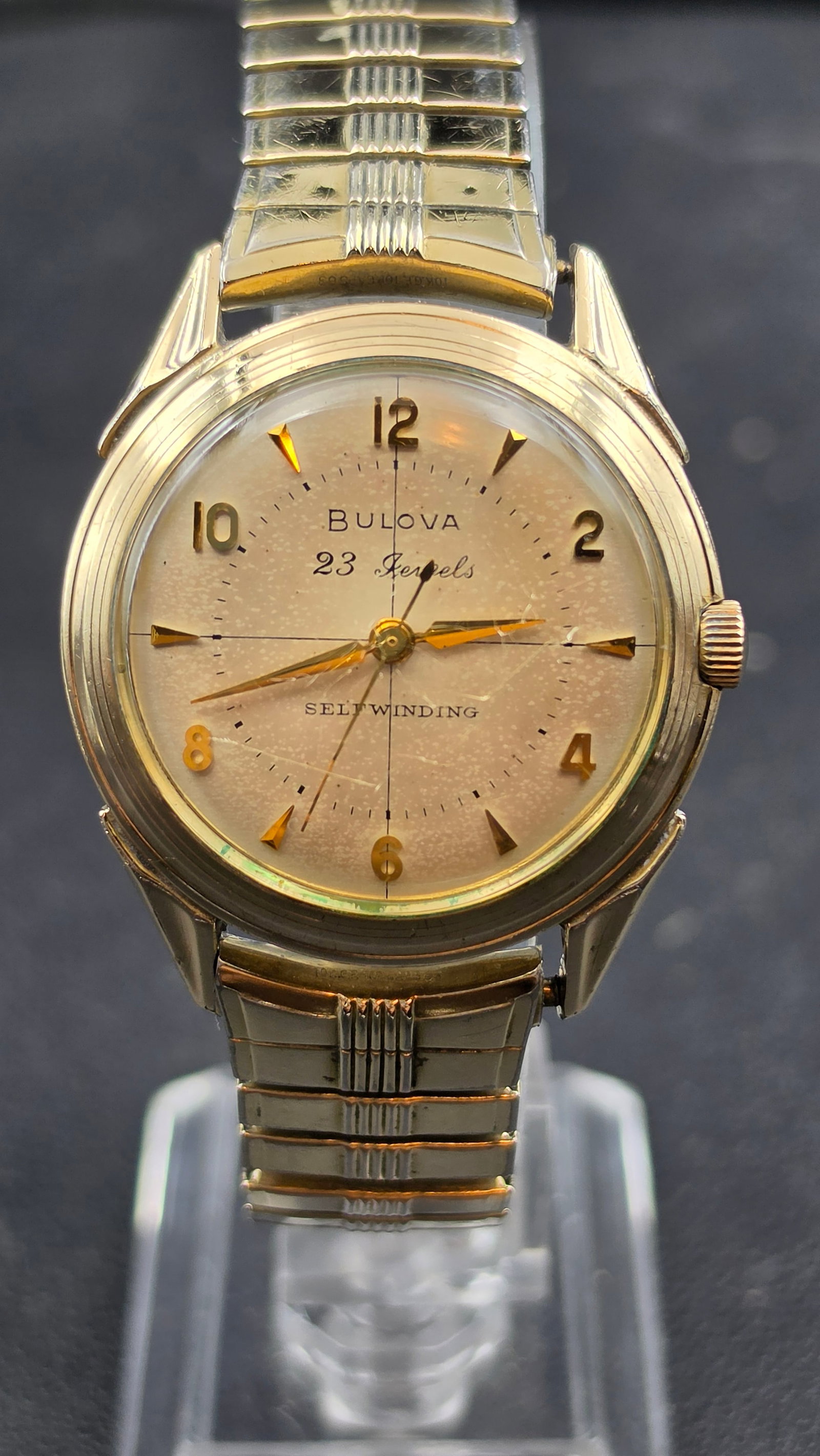 Vintage 1958 Bulova 23 Jewels 10BPAC Self Winding Automatic Watch 10K RGP Bezel 34mm: This is a vintage 1958 Bulova men's automatic wristwatch with a champagne dial signed "Bulova 23 Jewels Selfwinding," featuring applied gold Arabic numerals at 12, 2, 4, 6, 8, and 10, gold dagger-styl