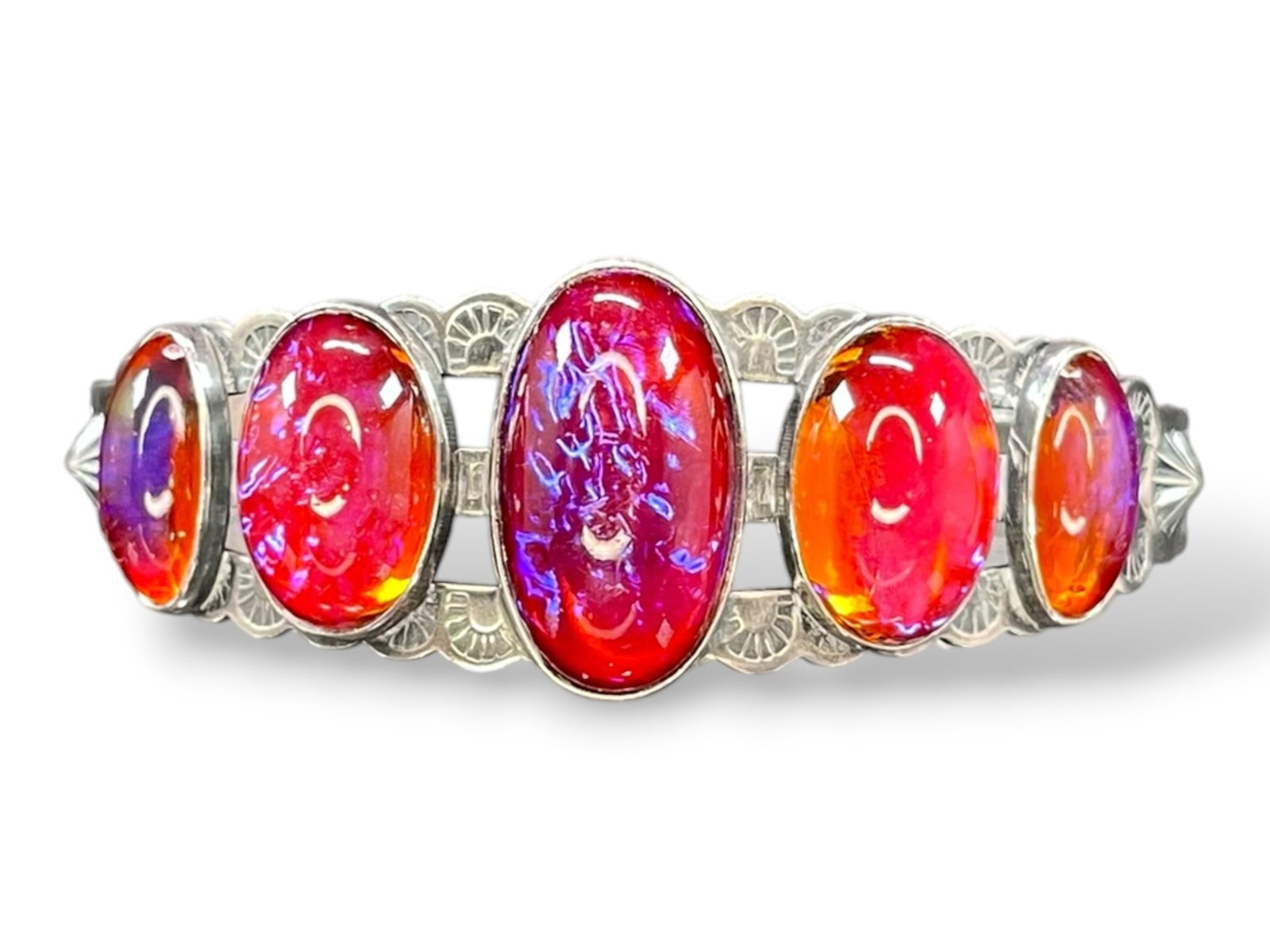 24g Navajo Sterling Silver Cuff Bracelet with Five Dragon’s Breath Opal Cabochons: A handmade sterling silver cuff bracelet in the Navajo style, set with five graduated oval cabochons of Dragon’s Breath opal glass — the vivid magenta-to-orange body color with flashing electric-b