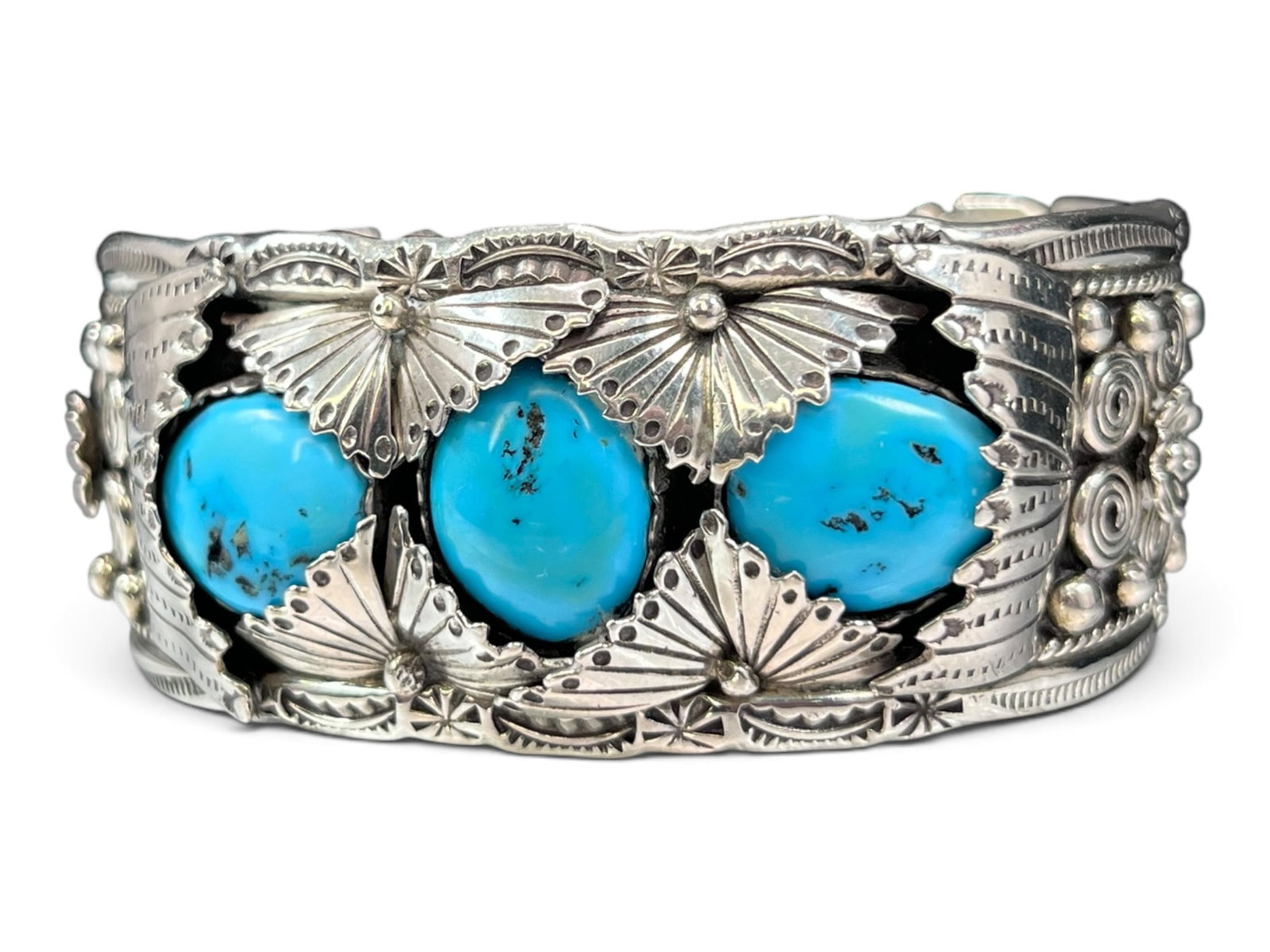 43g Intricately Detailed Navajo Sterling Silver Three Stone Turquoise Cuff Bracelet: A wide, heavily ornamented Navajo-style sterling silver cuff bracelet featuring three large natural turquoise cabochons set in an open-back shadow box style. The bracelet is exceptionally detailed wit