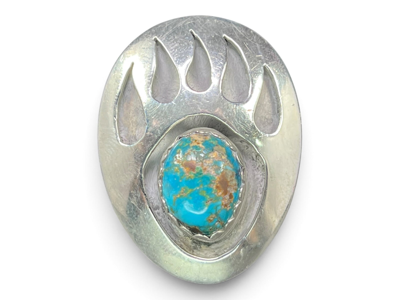 Size 10 James Martin Navajo Sterling Silver Bear Paw Ring: Picking this ring up, the weight sits mostly in its large domed face, cut into a bear paw silhouette with four elongated claw shapes and a thumb claw opened as negative-space cutouts. Nestled in the p