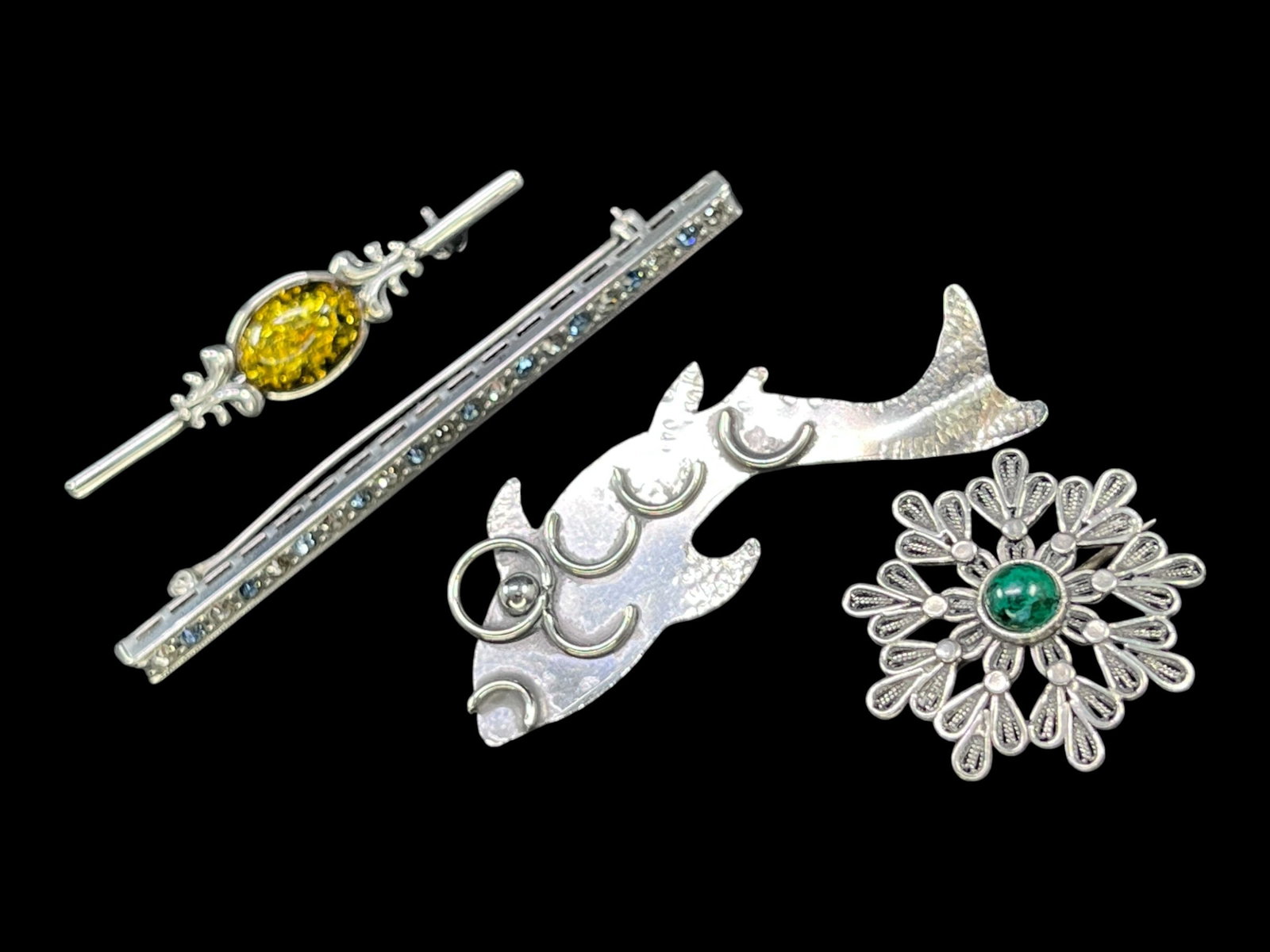 Lot of 4 Vintage Sterling Silver Brooches - 18g, Baltic Amber, Malachite, Fish, Rhinestones: The first is a scrolling acanthus-leaf bar brooch flanking an oval, amber-toned cabochon, with a C-clasp pin back; caliper measurement puts it at 2.17 in. long. The second is a delicate filigree snowf