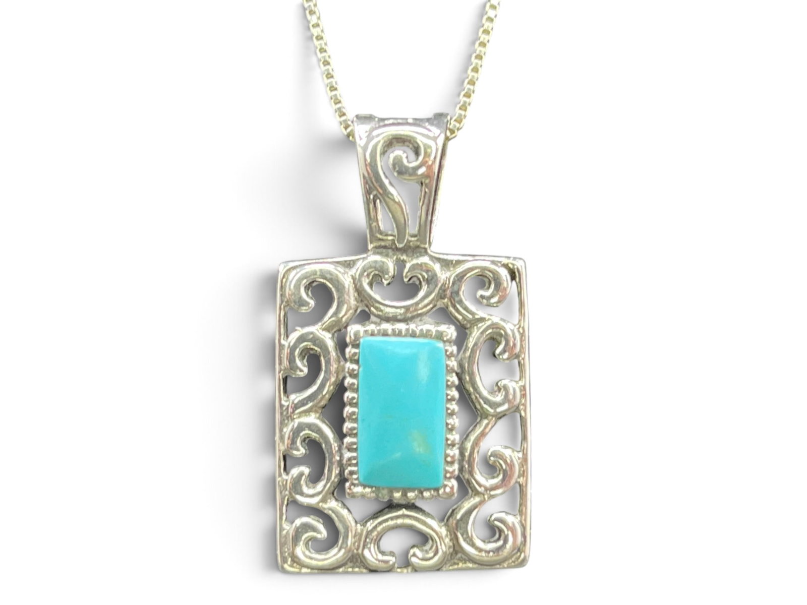 6g Marsala Company (MC) Sterling Silver Southwestern Open Scrollwork Turquoise Pendant Necklace: A rectangular sterling silver pendant featuring an ornate open filigree frame with scrollwork and curling vine motifs throughout. The center houses a bezel-set rectangular cabochon turquoise stone sur