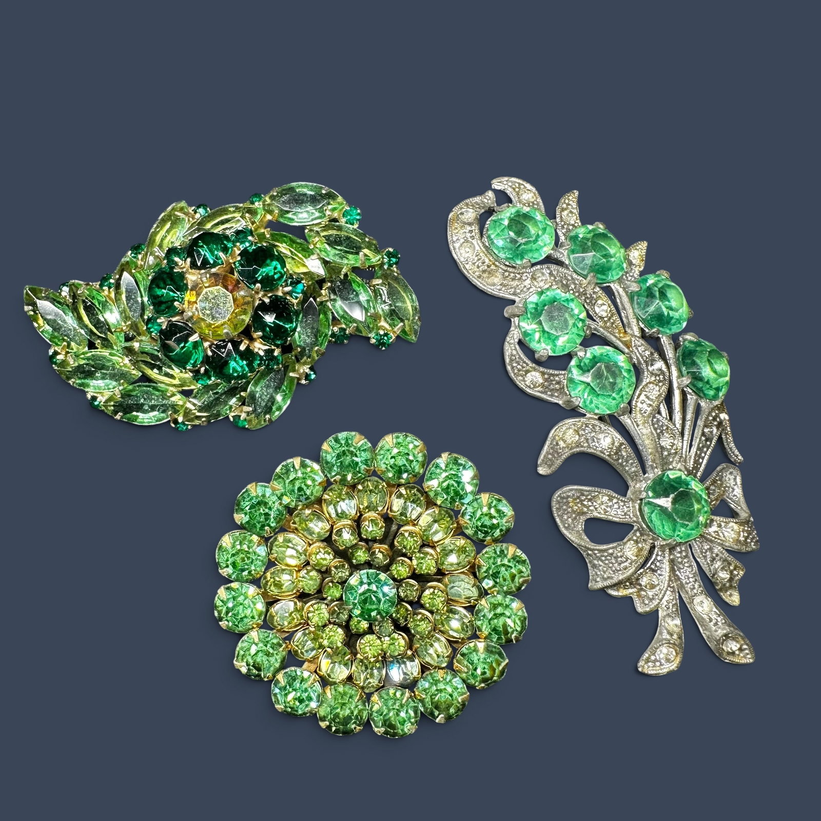 Vintage Green Rhinestone Floral Brooch Pin Lot: Vintage Green Rhinestone Floral Brooch Pin Lot:Brand/Model: No hallmark. Unidentified artisan/shop.Manufacturer Location: Not marked.Year Produced: Mid-20th century.Specs/Description: Lot of three vin