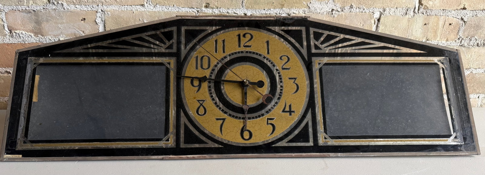 1920’s-1930’s Silver Lite Ad Clock Division Art Deco Metal Clock: This is an antique Art Deco mantel clock featuring a mirrored glass frame with integrated side picture frames. It is characterized by its geometric symmetry, stylized sunburst corner motifs, and promi