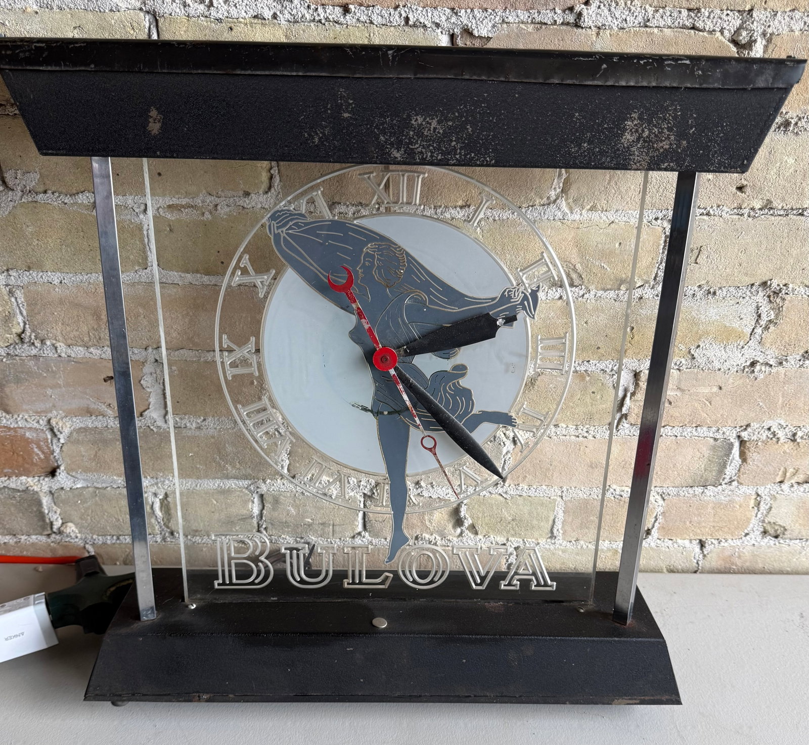 Bulova Late 1950’s “Goddess of Time” Motif Display Clock: This clock features Bulova's iconic Goddess of Time motif, which the company heavily used in its mid-century advertisements, watch cases, and marketing imagery. these were designed as illuminated elec