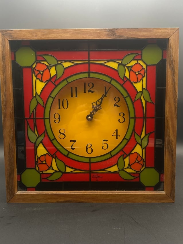 Elgin Stained Glass Style Wall Clock with Floral Art Design: Colorful Elgin wall clock featuring a decorative stained glass–inspired face with red, green, and yellow floral motifs. The clock operates on a single 1.5V AA battery and has an elegant vintage aest