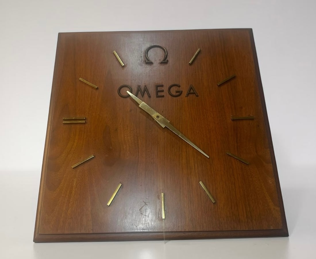 Vintage Omega Wood Wall Clock: Large vintage Omega wall clock with wood case, brass-tone markers and hands. Approx. 18” square. Shows age wear and marks on the wood. Untested; sold as found.