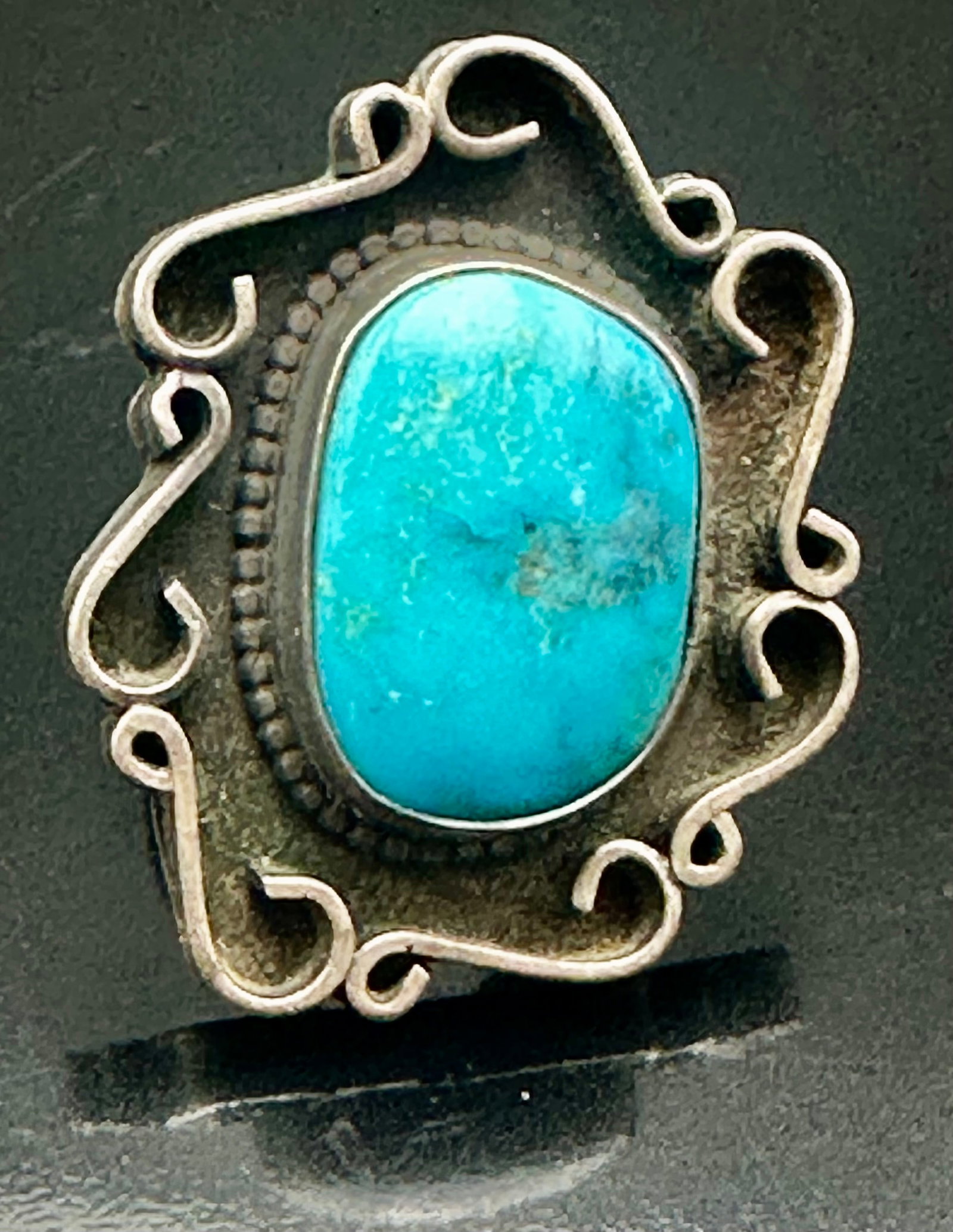 15g Vintage Native American Turquoise Sterling Silver Ring Unsigned: Vintage Native American sterling silver ring with a large turquoise stone and handmade scroll design around the setting. Nice old patina. Unsigned. Weighs 15 grams.