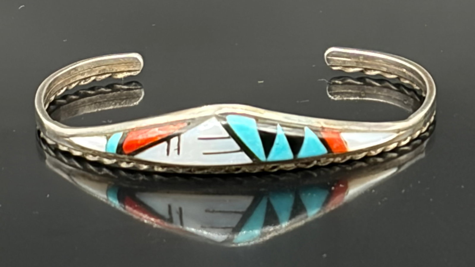 7.4 g Vintage Native American Zuni inlay cuff bracelet: This is a vintage Zuni Native American sterling silver cuff bracelet featuring traditional, finely hand-cut stone-to-stone mosaic inlay. The geometric design is precisely crafted using turquoise, red 