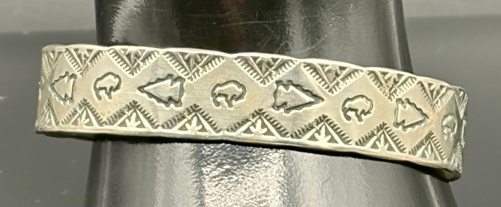 20.3 g Symbols Design Bangle Sterling Silver: This is an authentic vintage Navajo sterling silver cuff bracelet handcrafted by artisan Wes Willie. The exterior features meticulous hand-stamped geometric triangular borders flanking alternating mot