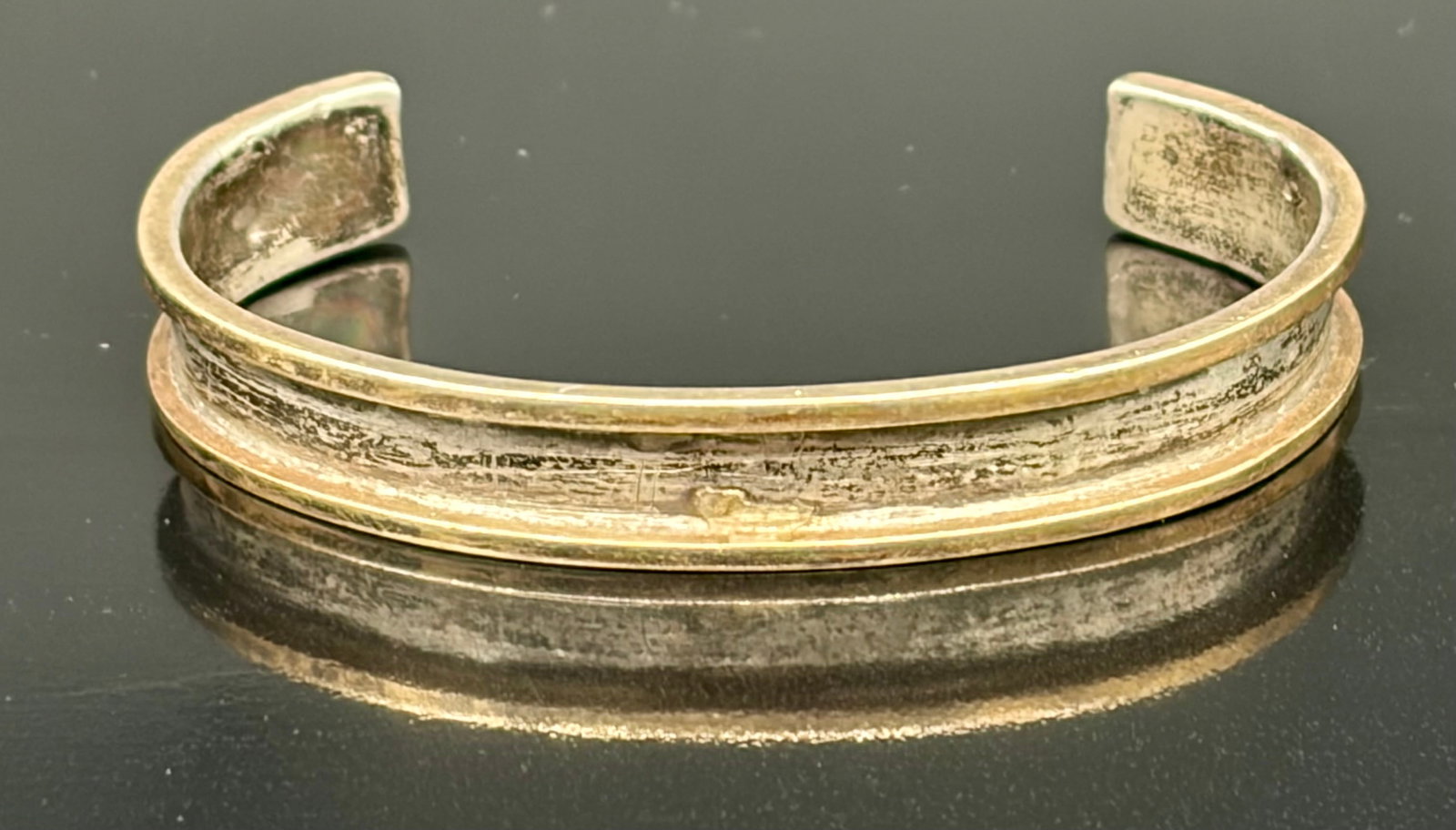 13.6 g Mixed-Metal Channel Cuff Bracelet Sterling Silver: This vintage open cuff features a striking mixed-metal channel design, pairing warm yellow gold outer rims with a heavily textured, darkened sterling silver inner trough. The interior band is cleanly 