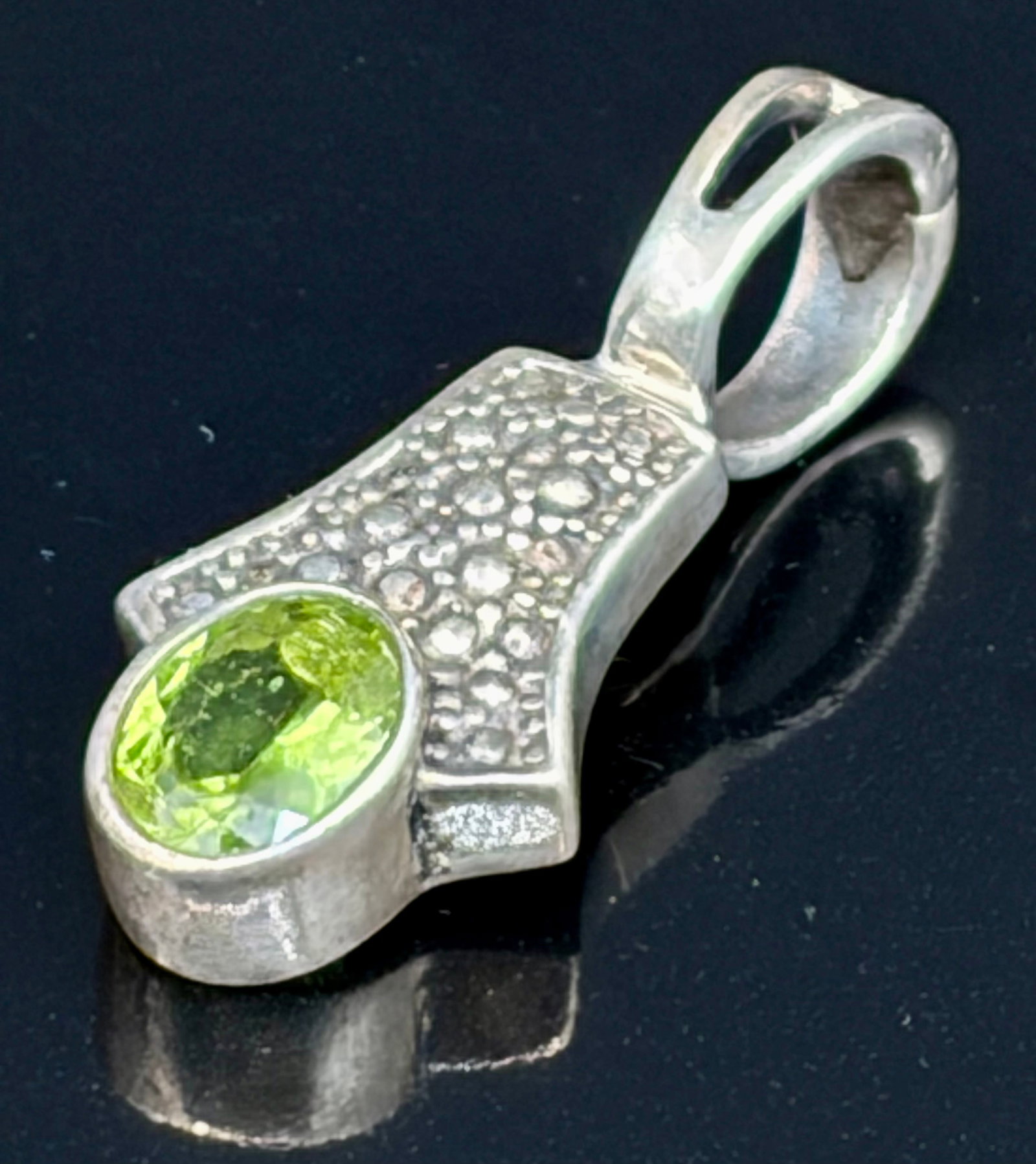 9.8 g Vintage Sterling Silver Peridot & Marcasite Pendant: An elegant vintage-style sterling silver pendant featuring a central oval-faceted peridot gemstone with a vibrant, translucent lime-green hue. The peridot is securely nested within a solid bezel setti
