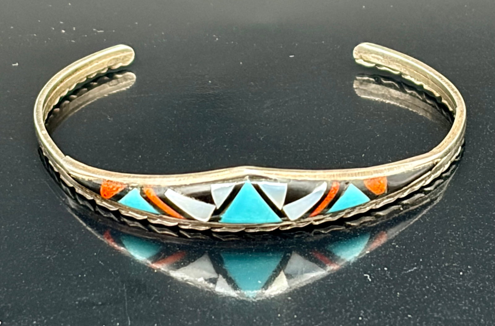 7.6 g Sterling Silver Cuff Bracelet Zuni John & Rosalie Bowannie Turquoise Navajo: This Sterling Silver Cuff Bracelet features turquoise stones sourced from the Zuni tribe, showcasing traditional Navajo design elements. The bracelet is crafted with sterling silver and features coral