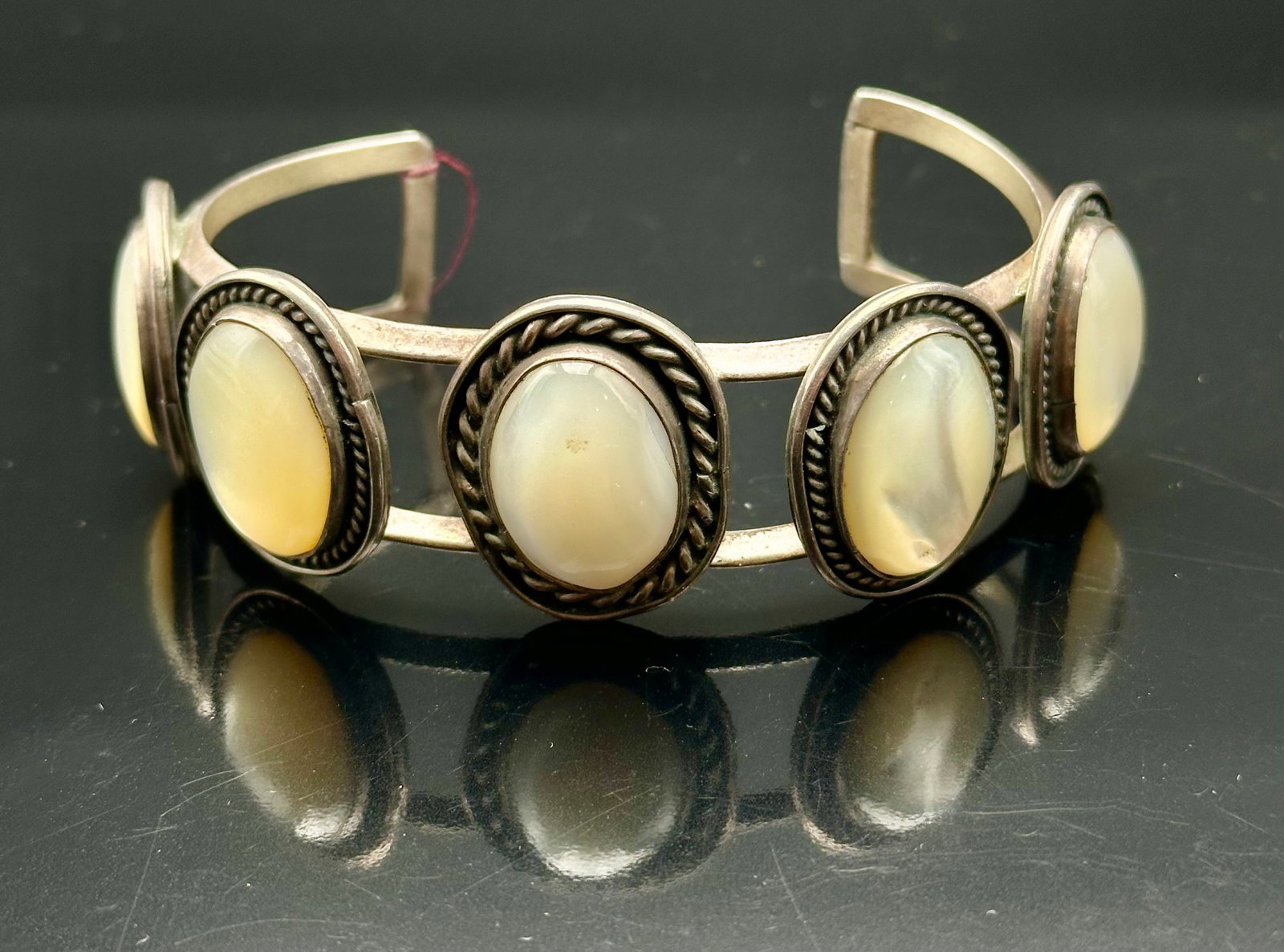 48g Vintage Navajo Sterling Silver Mother of Pearl Cuff Bracelet: Vintage sterling silver cuff bracelet set with five oval mother-of-pearl stones. Open double-band design with twisted rope details and nice old patina. Weighs 48g. Unsigned. Please review all photos f