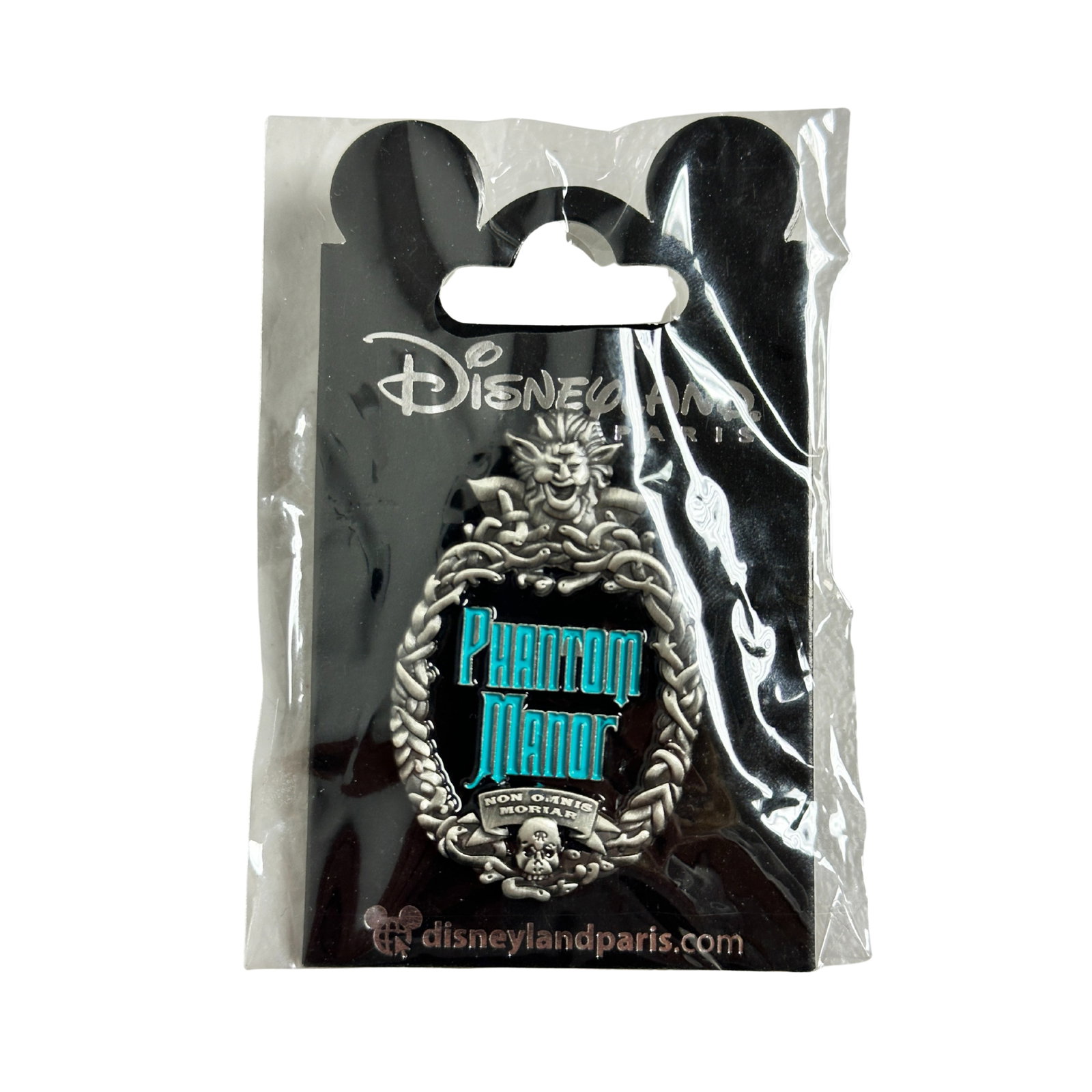 Disney DLP Haunted Mansion/Phantom Logo Pin: Disney DLP Haunted Mansion/Phantom Logo Pin. This oval silver metal pin has an outside edge scroll design with a skull at the bottom and a face at the top. The inside is black with light blue script t