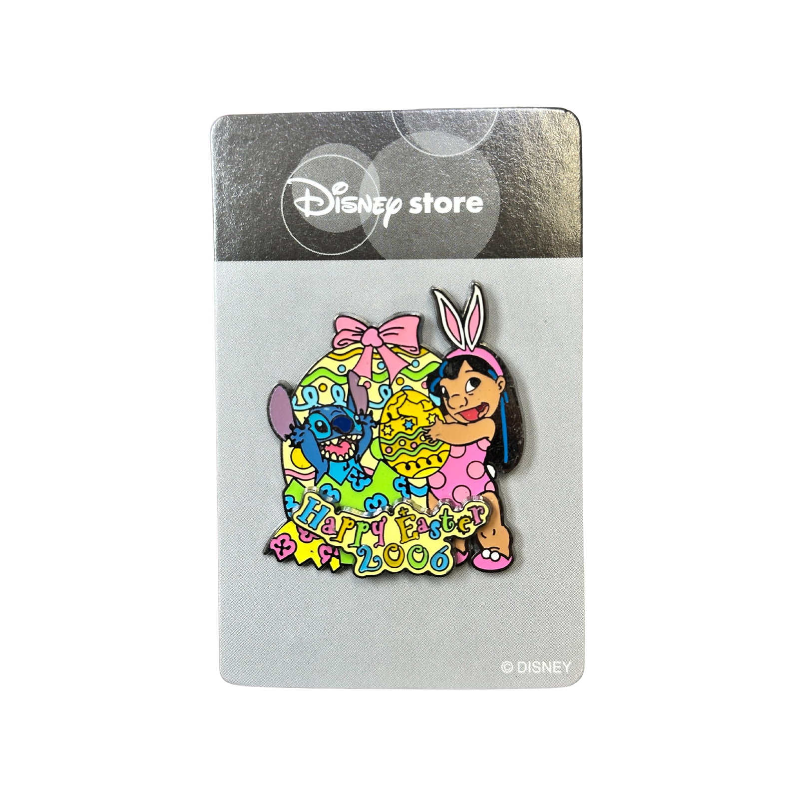 Disney JDS Lilo & Stitch Happy Easter 2006 Pin: Disney JDS Lilo & Stitch Happy Easter 2006 Pin. Lilo and Stitch are standing in front of a colorful Easter egg. The top of egg is decorated with a pink ribbon. Lilo holds another egg in her hand. It l