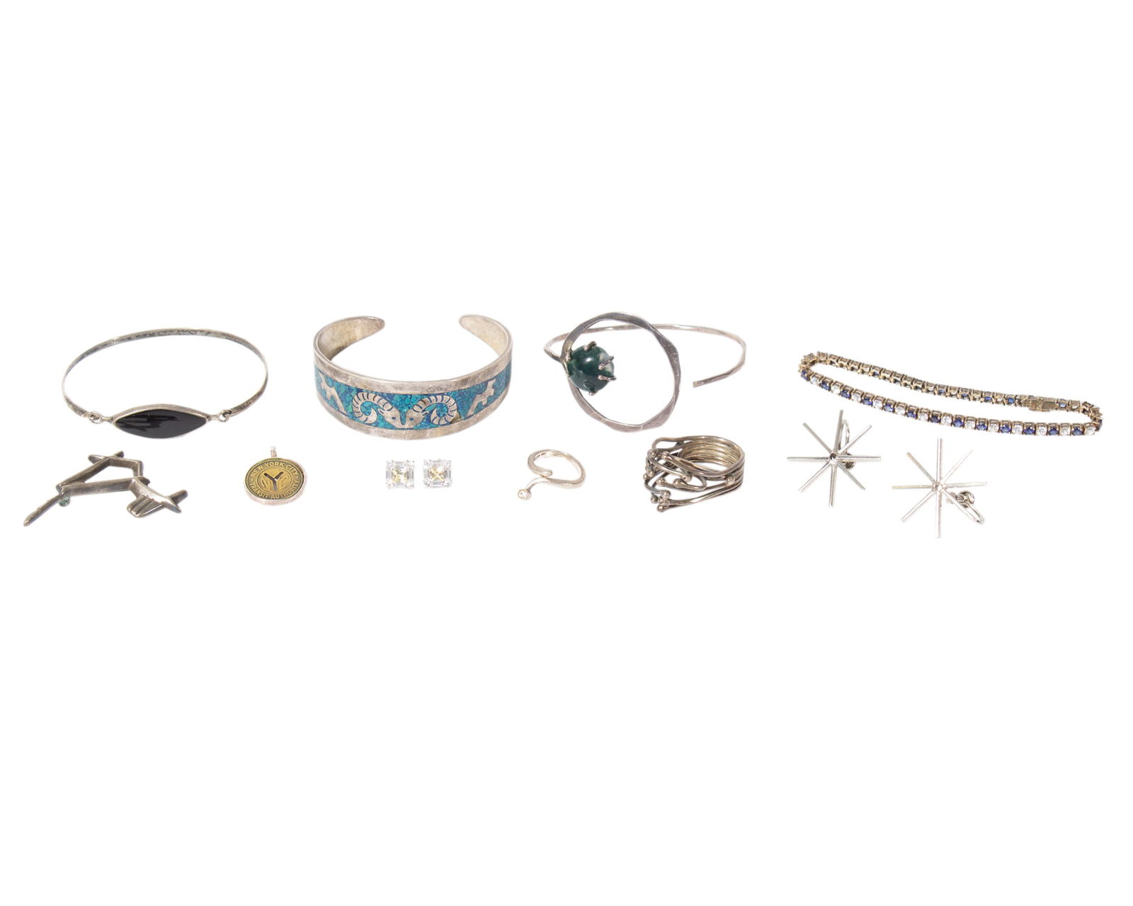 Sterling and Silver Jewelry: Group of sterling silver and silver jewelry. Included are four bracelets, two rings, a horse pin, a pair of post back earrings, a pair of screw back earrings, and a pendant made from a New York C