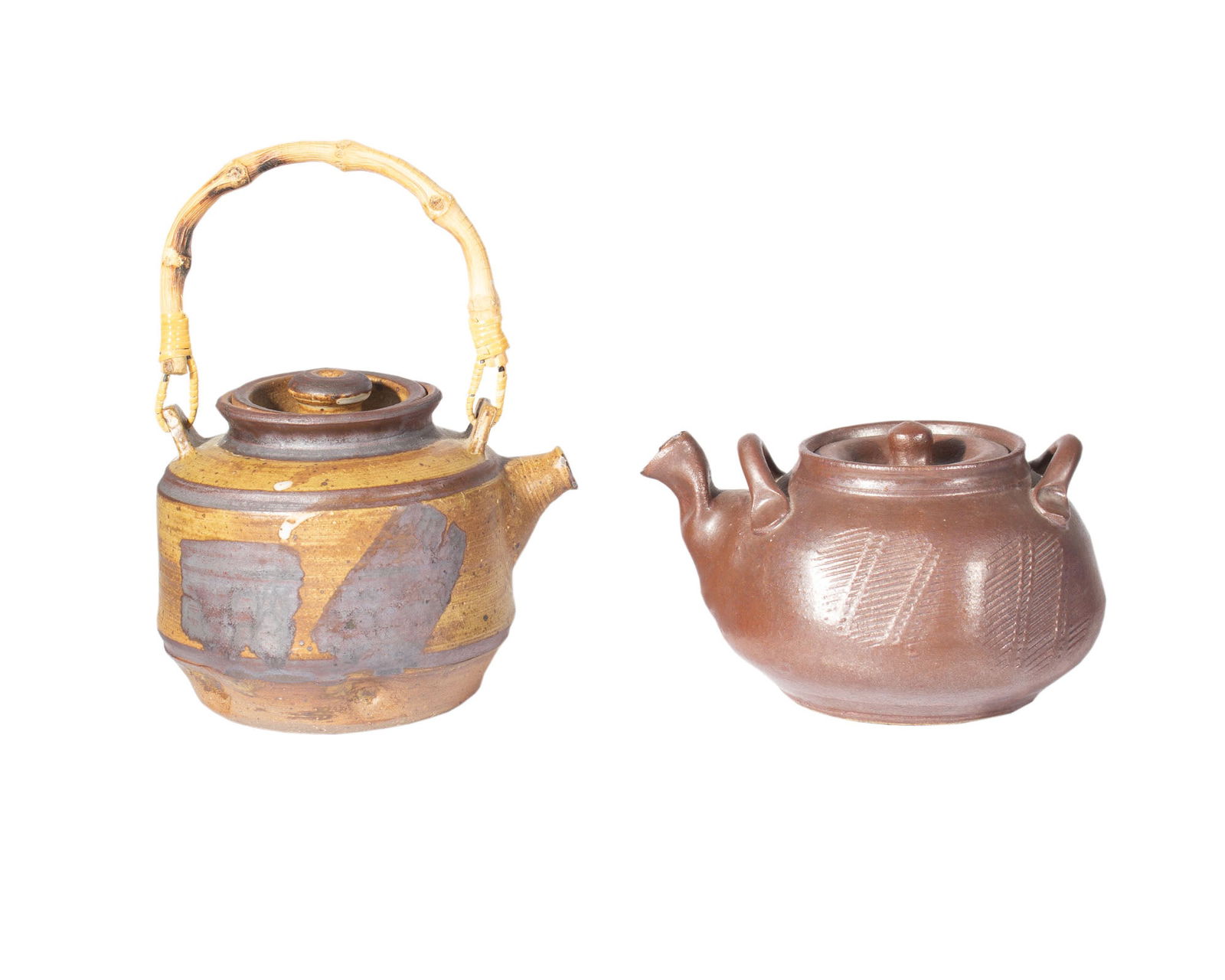 Warren MacKenzie Attrib. Studio Pottery Teapots: Two studio pottery teapots attributed to the American ceramic artist Warren MacKenzie. Measurements: 7" W x 4.25 H x 6 D (solid brown teapot). In house shipping available.