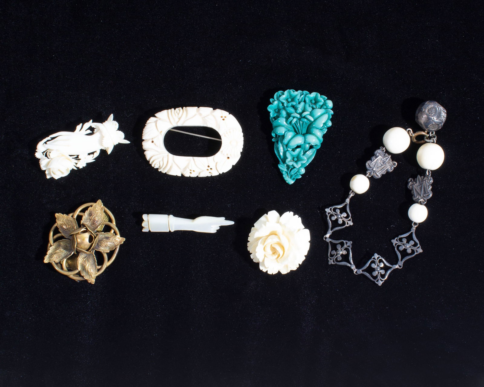 Antique and Vintage Jewelry: Group of antique and vintage jewelry. Included are two dress clips, a bracelet, a carved mother of pearl hand pin, and three pins/brooches. Measurements: 2.25" W x 1.5" H (oval 