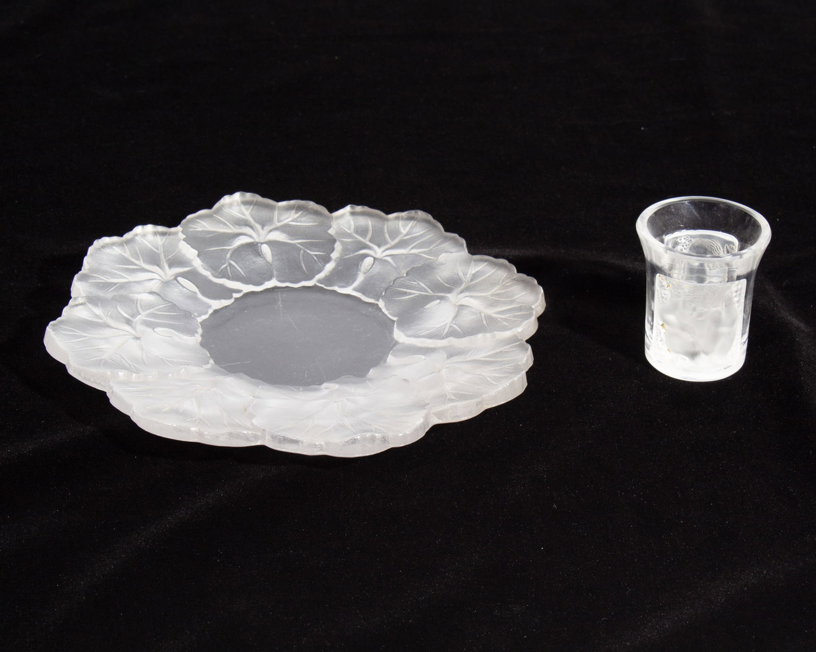 Lalique France Crystal "Honfleur" Dish and "Les Enfants" Cordial: Two pieces of Lalique. Included is a "Honfleur" dish and a "Les Enfants" cordial glass. Both marked "Lalique France" to underside. Measurements: 5.75" W x