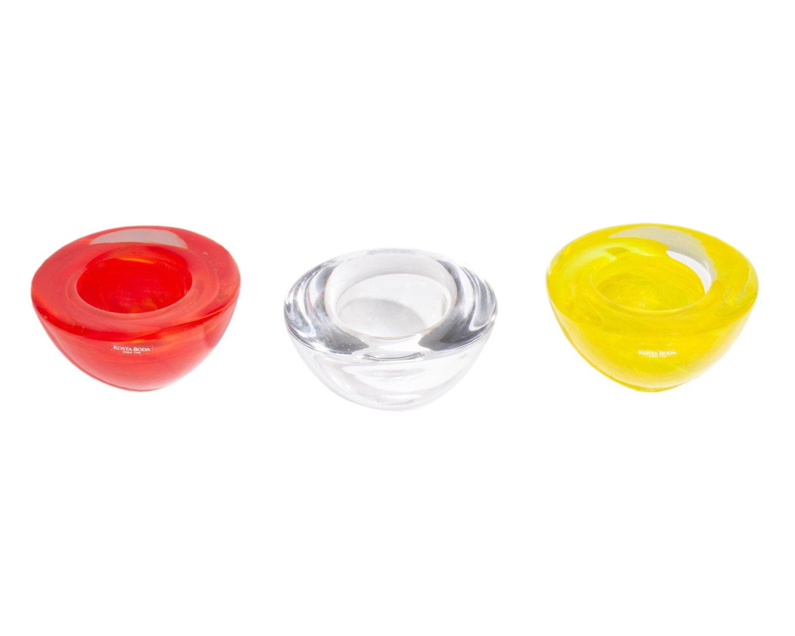 Anna Ehrner Kosta Boda "Atoll" Glass Bowls: Group of three glass "Atoll" bowls in yellow, red, and clear glass designed by Anna Ehrner (Swedish; born 1948) for Kosta Boda. Two of the bowls are marked with a Kosta Boda sticker. 