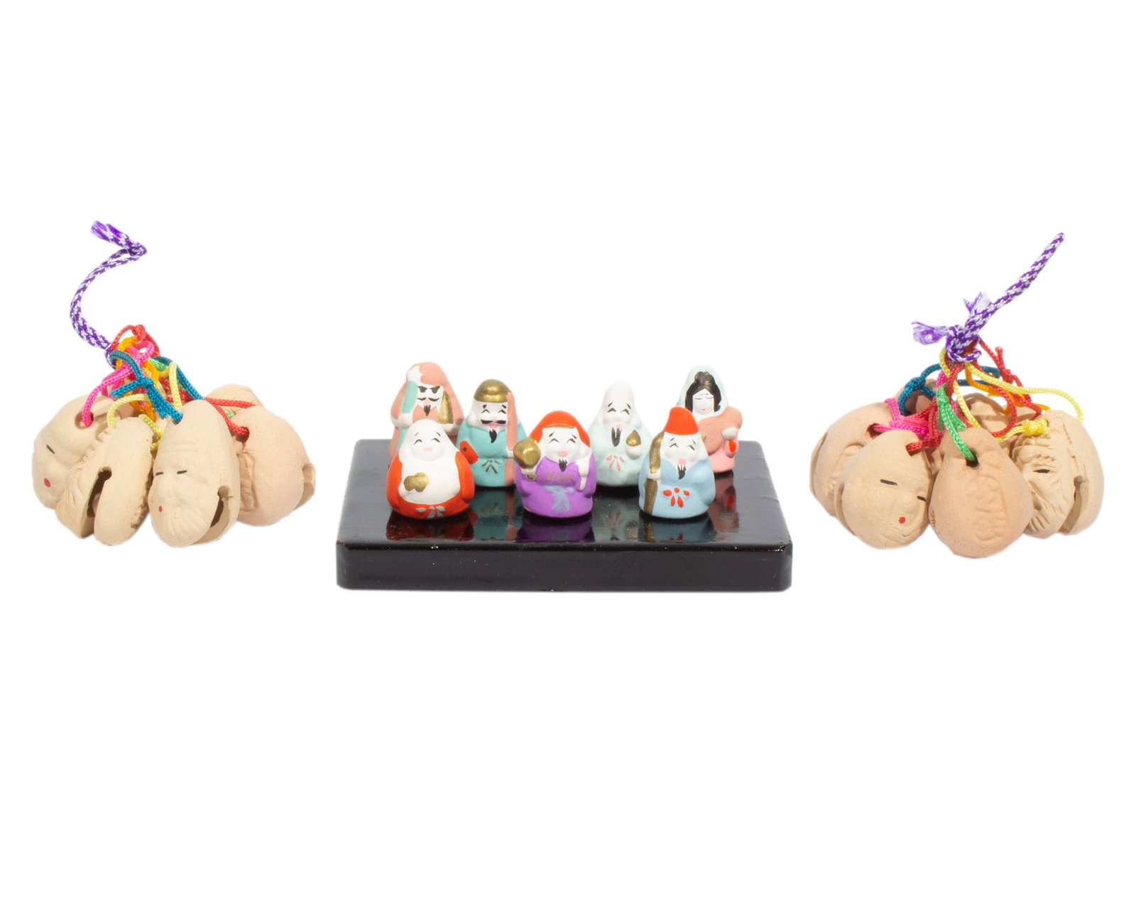 Japanese 1980s Seven Luck Gods Miniature Dolls Dorei Bells: 1980s ceramics from Japan. Included is a set of Seven Lucky Gods miniature dolls in original box, comes with wooden displayed stand. Also included are two sets of ceramic Seven Lucky Gods dorei