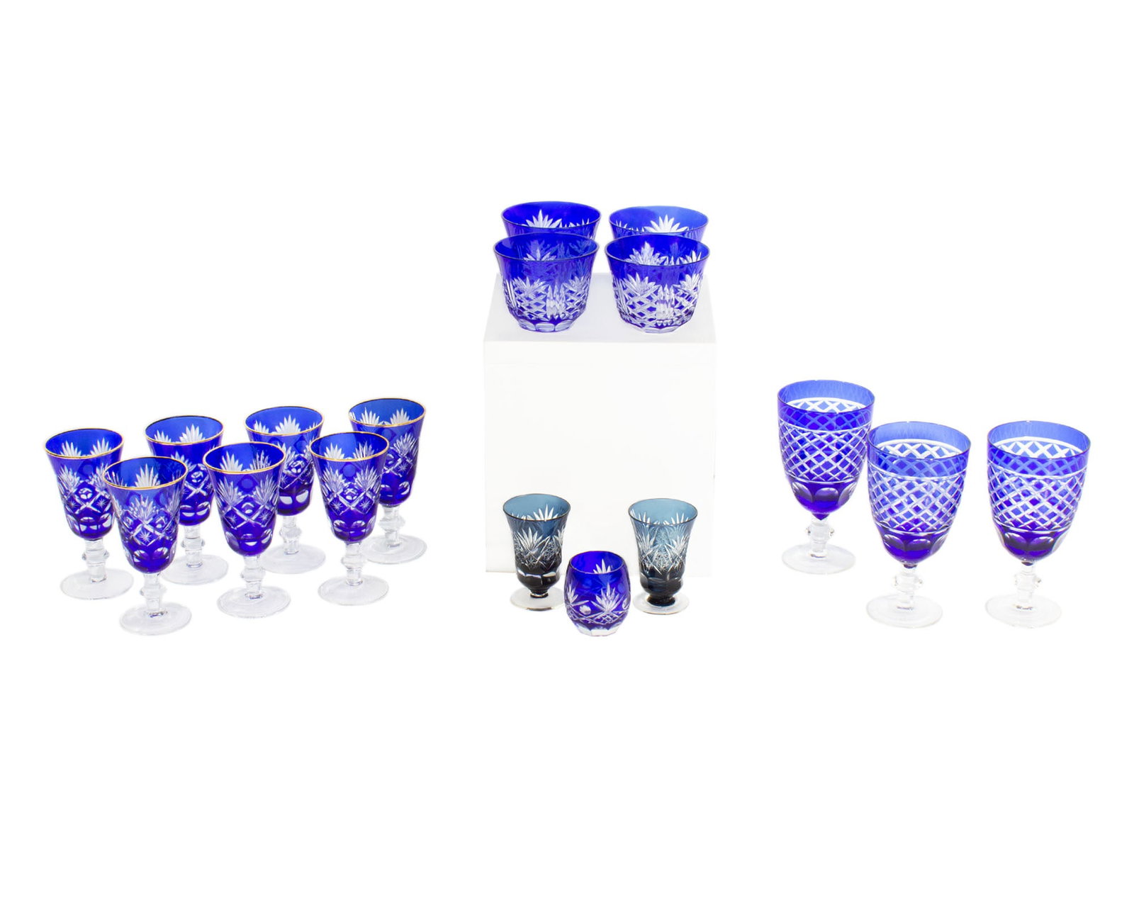 Cobalt and Blue Cut to Clear Glasses, 17 Pieces: 17 pieces of cobalt and dark blue cut to clear glasses. Measurements: 3" W x 5.75" H x 3" D (tallest glass). In house shipping available.