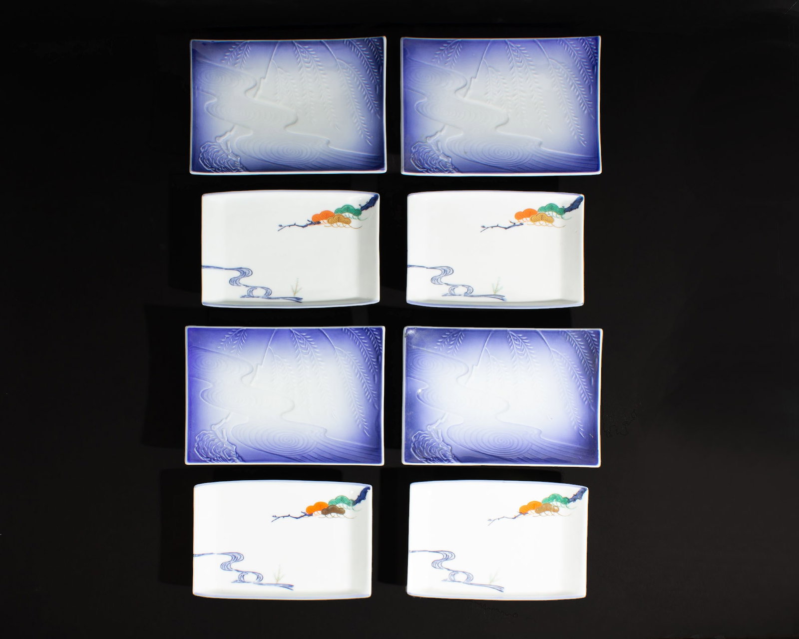 Japanese Porcelain Dishes, 8 Pieces: Two sets of four rectangular Japanese porcelain dishes. Each marked to the underside. Measurements: 9.5" W x 1.5" H x 6.5" D (larger dish). In house shipping