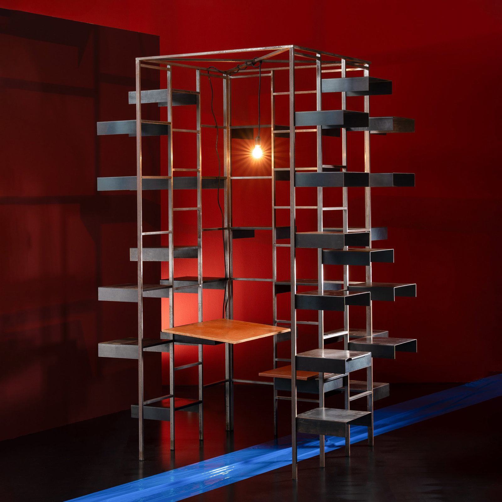 MEYER VOGGENREITER & REINHARD MÜLLER BOOKSHOP: A rare bookcase designed by members of the Pentagon Group. It comprises a seat a desk and a pendant light. The bookcase is made of metal whilst the seat and desk are upholstered in leather. Produced b