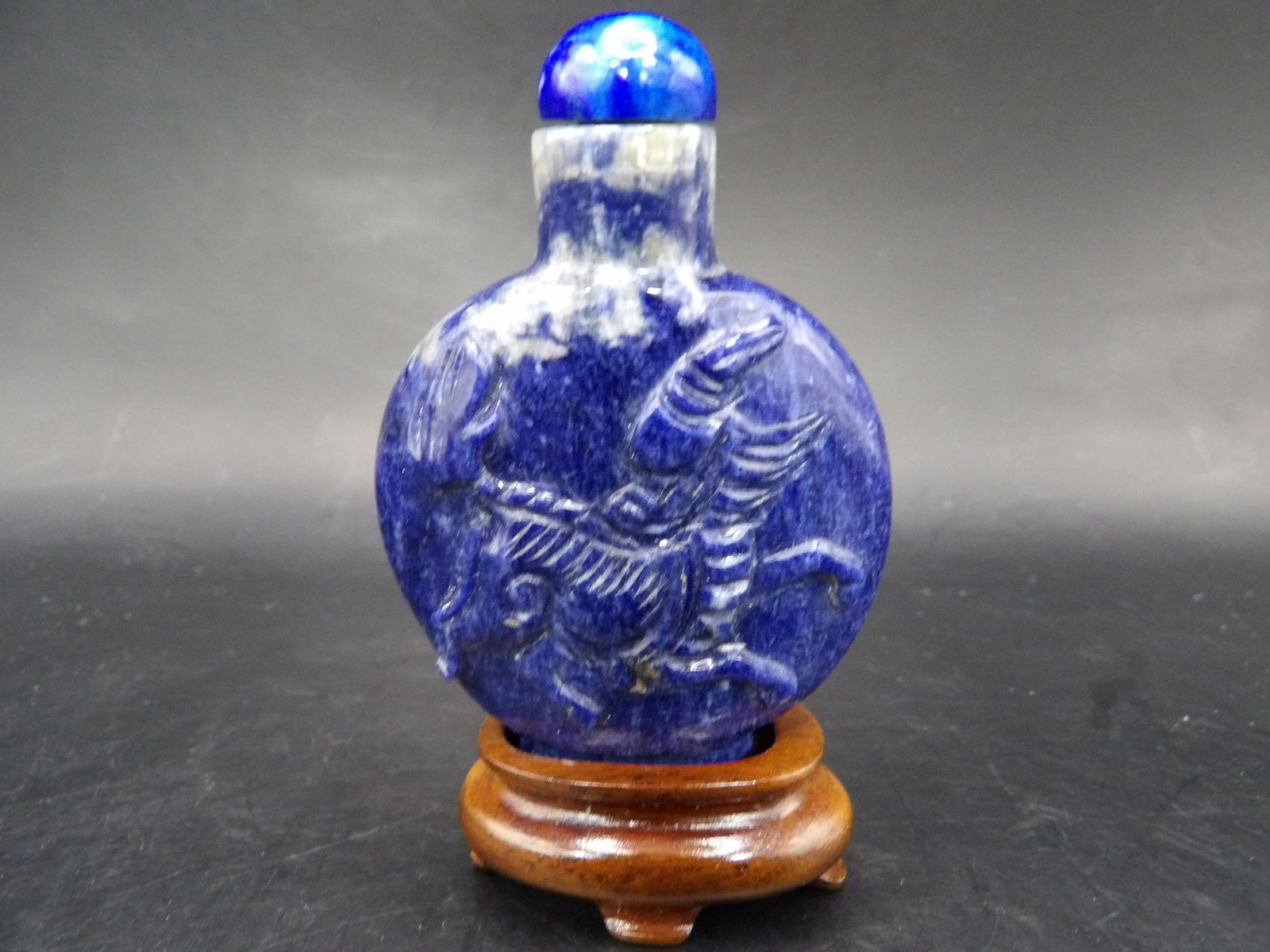 Chinese Qing dynasty carved lapis lazuli snuff bottle with custom wooden stand (1 of 4)