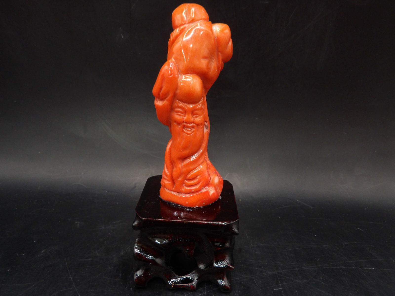 Chinese coral Longevity God carving adhered to wooden base: 5.5 inches height including base.