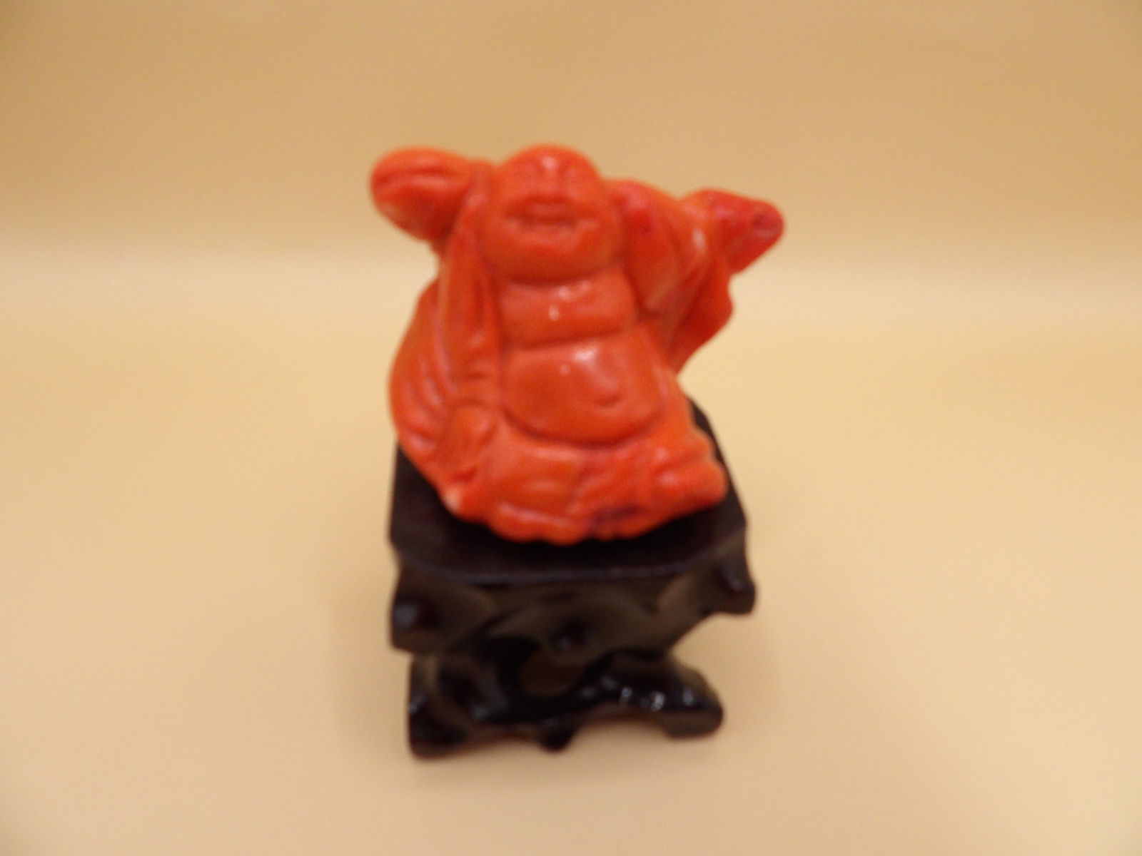 Chinese coral buddha carving adhered to wooden stand: 3.2 inches height with base.