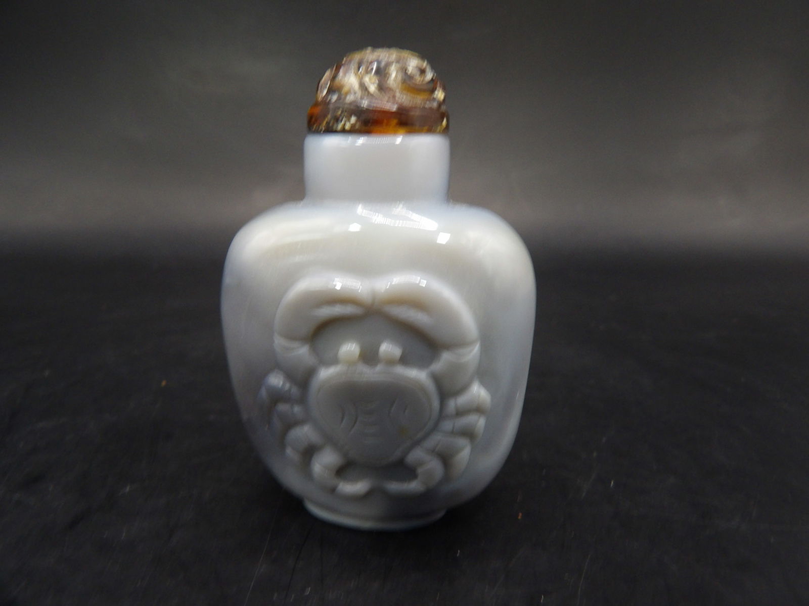 Qing dynasty banded agate well hollowed snuff bottle with raised crab motif and amber stopper: 2.1 inches height.