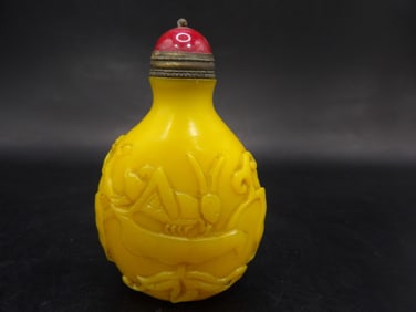 Chinese egg yolk color glass snuff bottle with raised motif and Qing dynasty Qianlong mark
