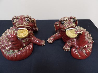 pair of Chinese guardian lions holding Chinese coins statues
