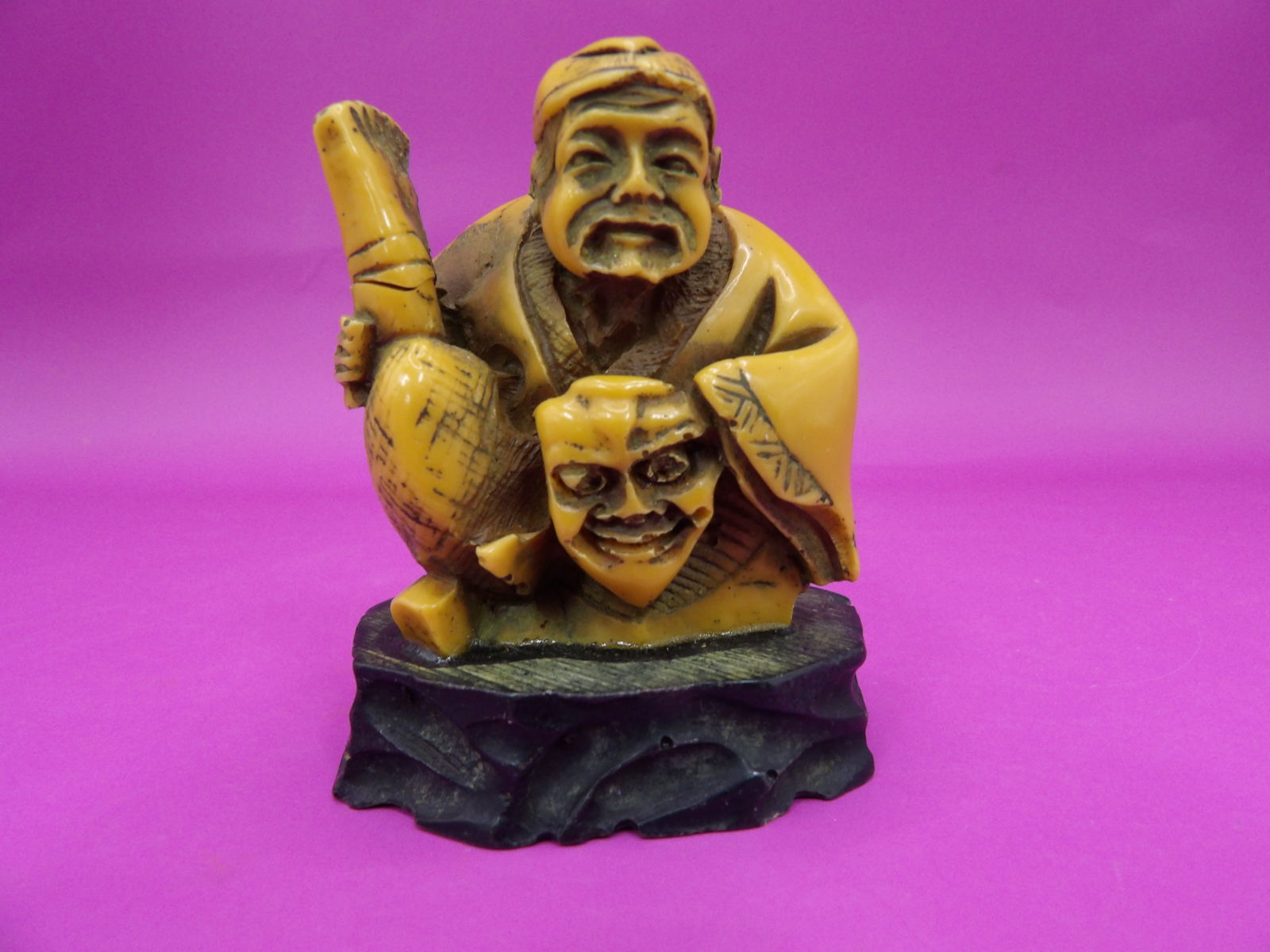 antique Japanese resin netsuke depicting a man holding a face mask on custom base (1 of 4)