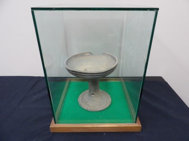 Ancient pottery in a large thick and heavy glass display case.