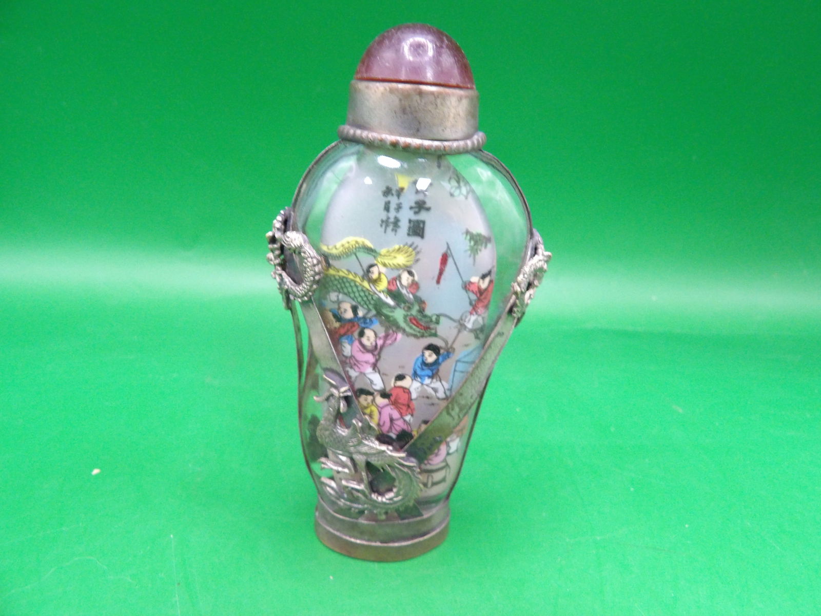 Chinese reverse inside hand painted with dragon play scene glass snuff bottle and filigree details: 3.3 inches height. Signed silver in Chinese on the bottom.