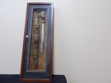 framed Dayak Parang Ilang knife and sheath with intricate decorations
