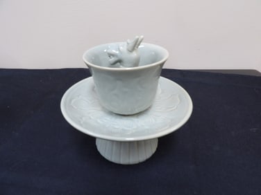 Chinese celadon porcelain tea cup with a dragon on ornate base