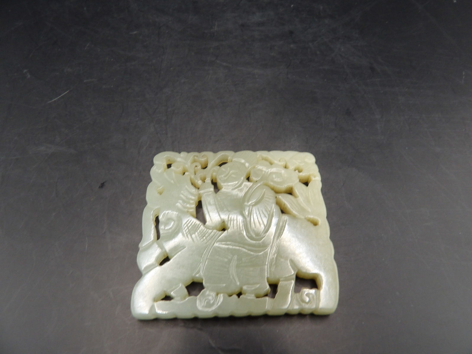 Qing dynasty antique Chinese Nephrite Jade Plaque Carving: Carved on both sides a woman holding flowers riding a beast. 2 inches length. 34 grams.