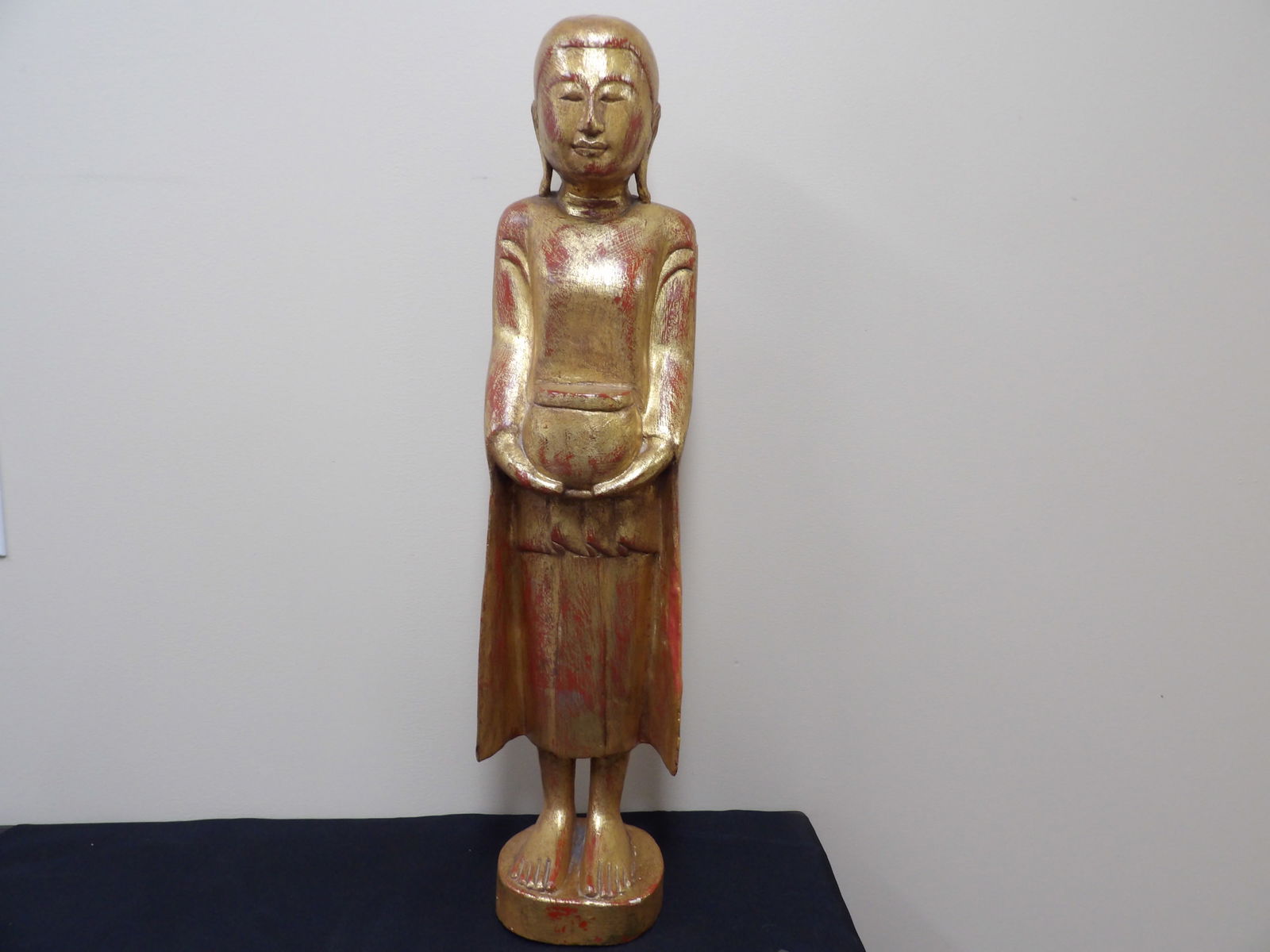 antique tall giltwood standing Southeast Asian figure holding an alms bowl: Approx. 30 inches height.