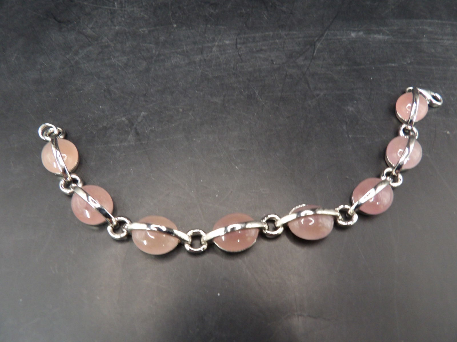 fine sterling silver framed pink oval cabochon stone bracelet marked 925: Marked 925 on clasp. 7 inches long. 18 grams.
