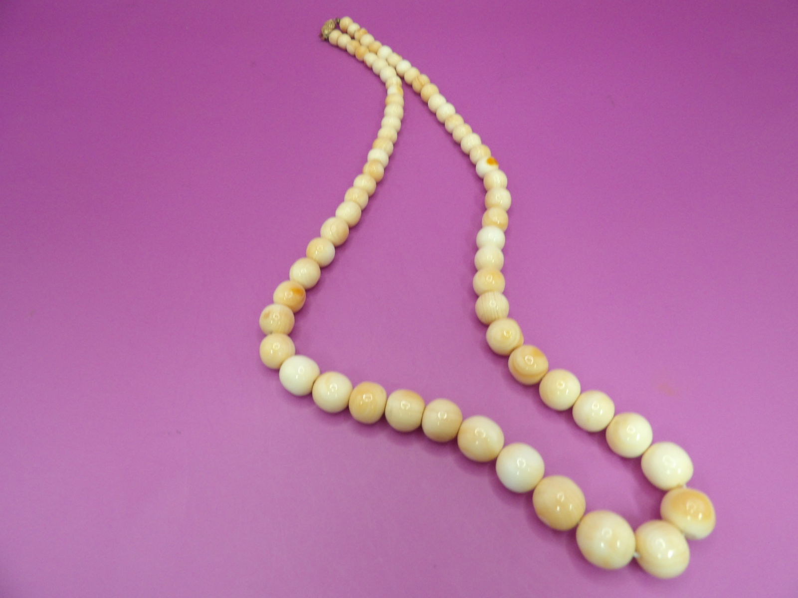 angel skin coral graduated beaded necklace with 14k gold clasp marked: Approx 22 inches long. 77 grams. Marked 14k on clasp.