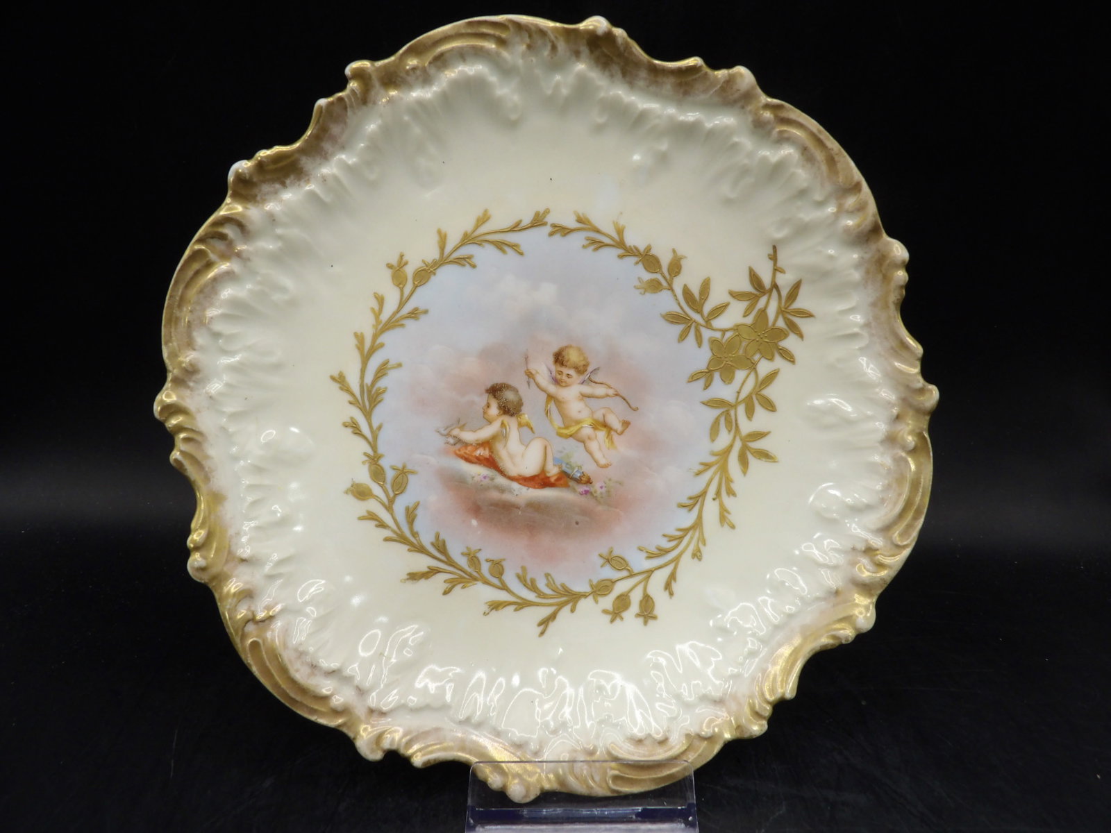 late 19th century Limoges porcelain plate with cherub motif and gilded rim: 8 inches diameter.