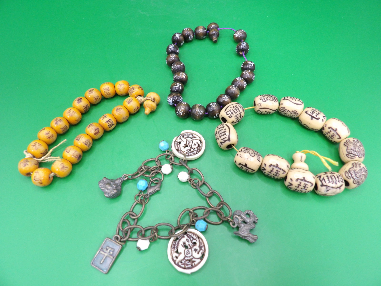 lot of 4 Chinese prayer beads bracelets with Chinese calligraphy: Elastic bands are loose due to age. One charm has chip on metal bracelet.
