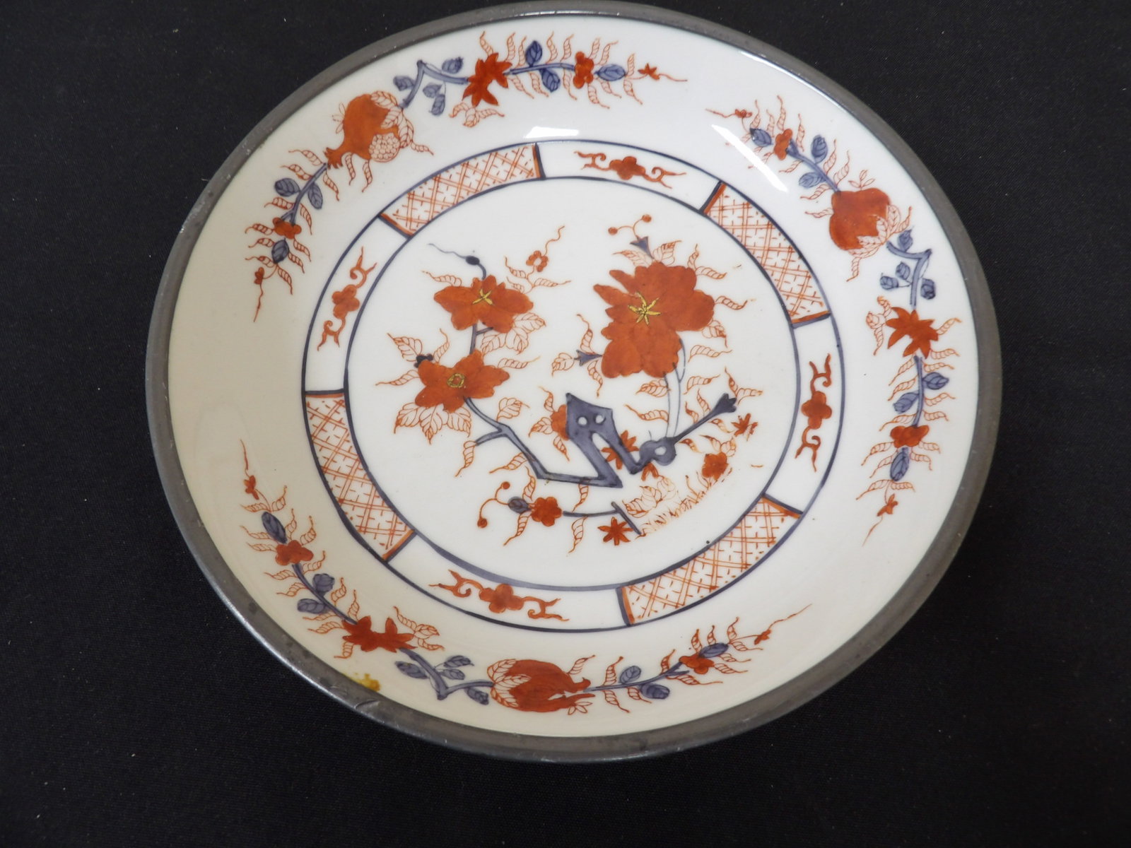 vintage Chinese porcelain plate with floral motifs encased in metal: 7.8 inches diameter. Decorated in Hong Kong. Heavy 1.8 lbs.