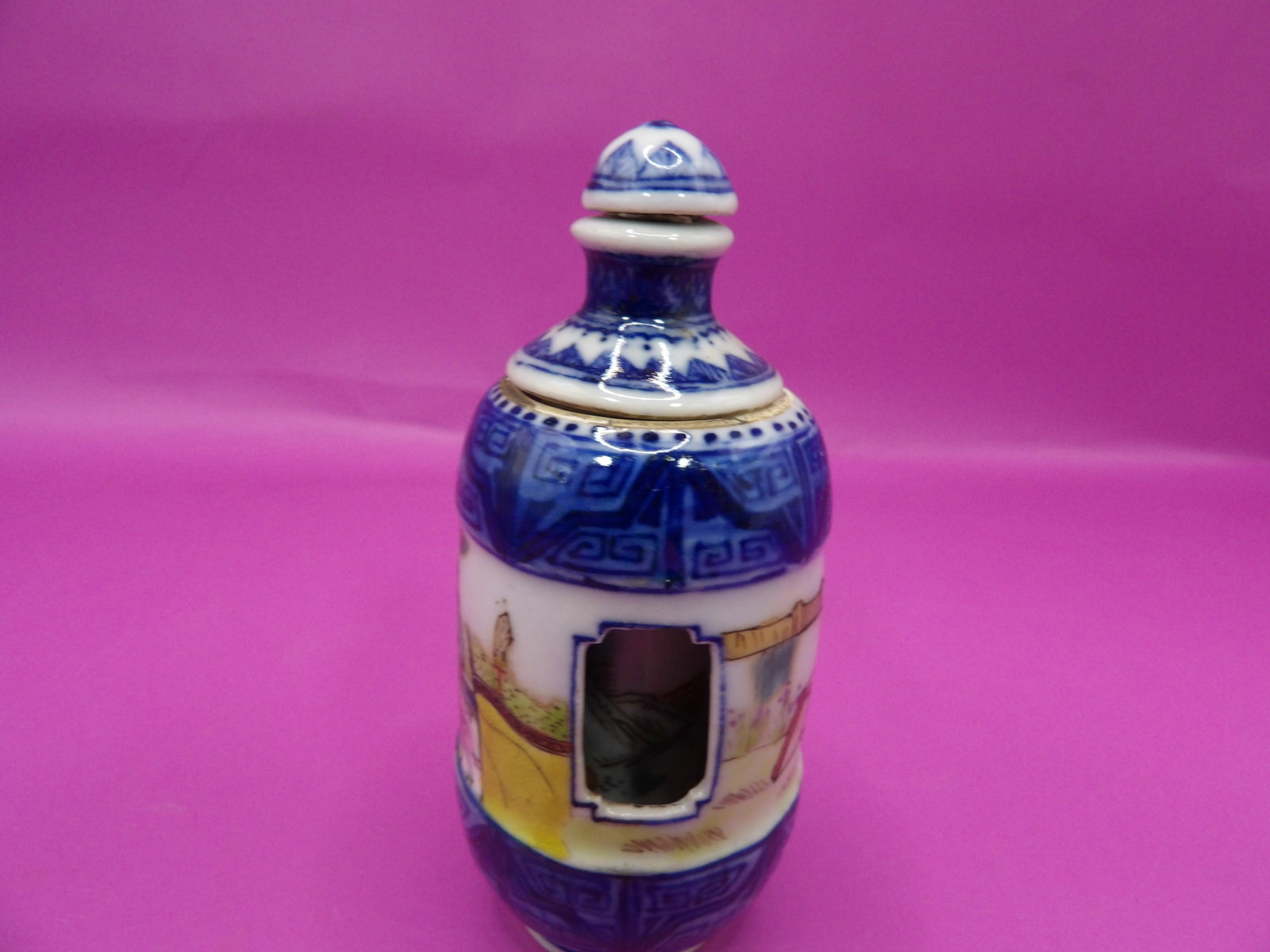 Chinese rotating porcelain snuff bottle with warrior motif and Qing dynasty Qianlong mark: 3 inches height.