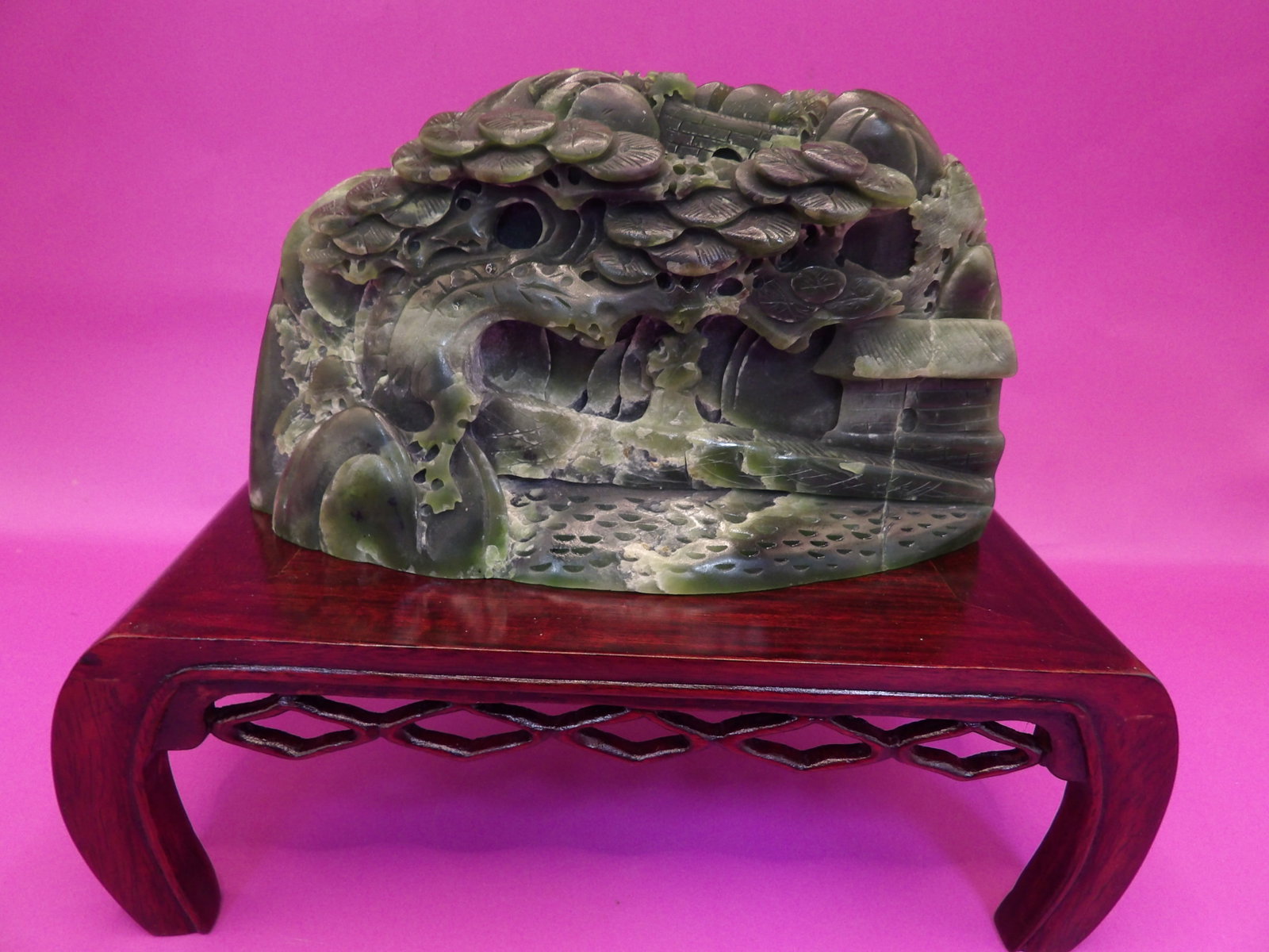 Chinese nephrite jade carved landscape boulder featuring pine tree motifs: 5.5 inches length. 489 grams.