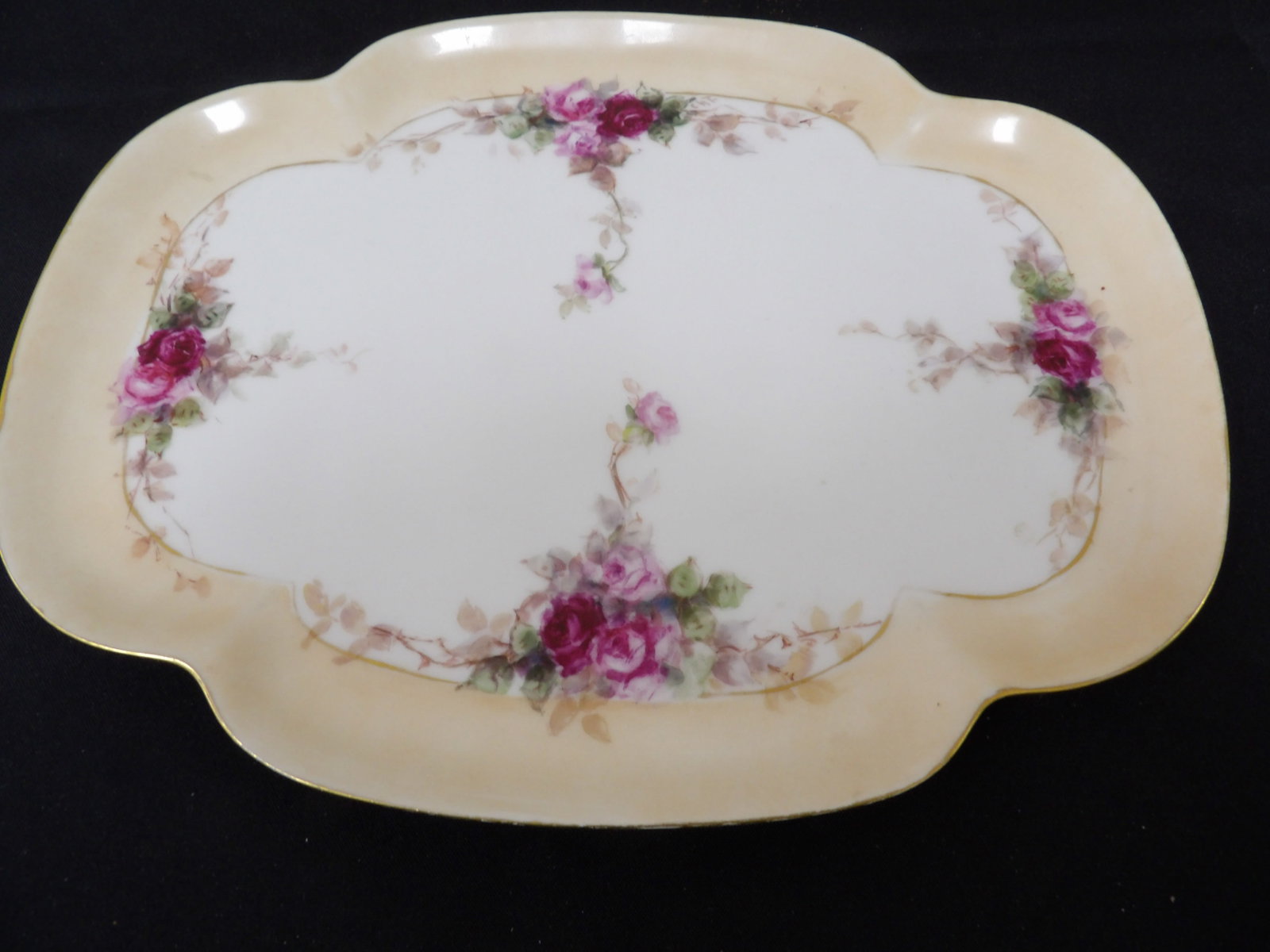 hand painted porcelain tray with roses and gold trim circa 1920 to 1940: Approx. 12 inches length.